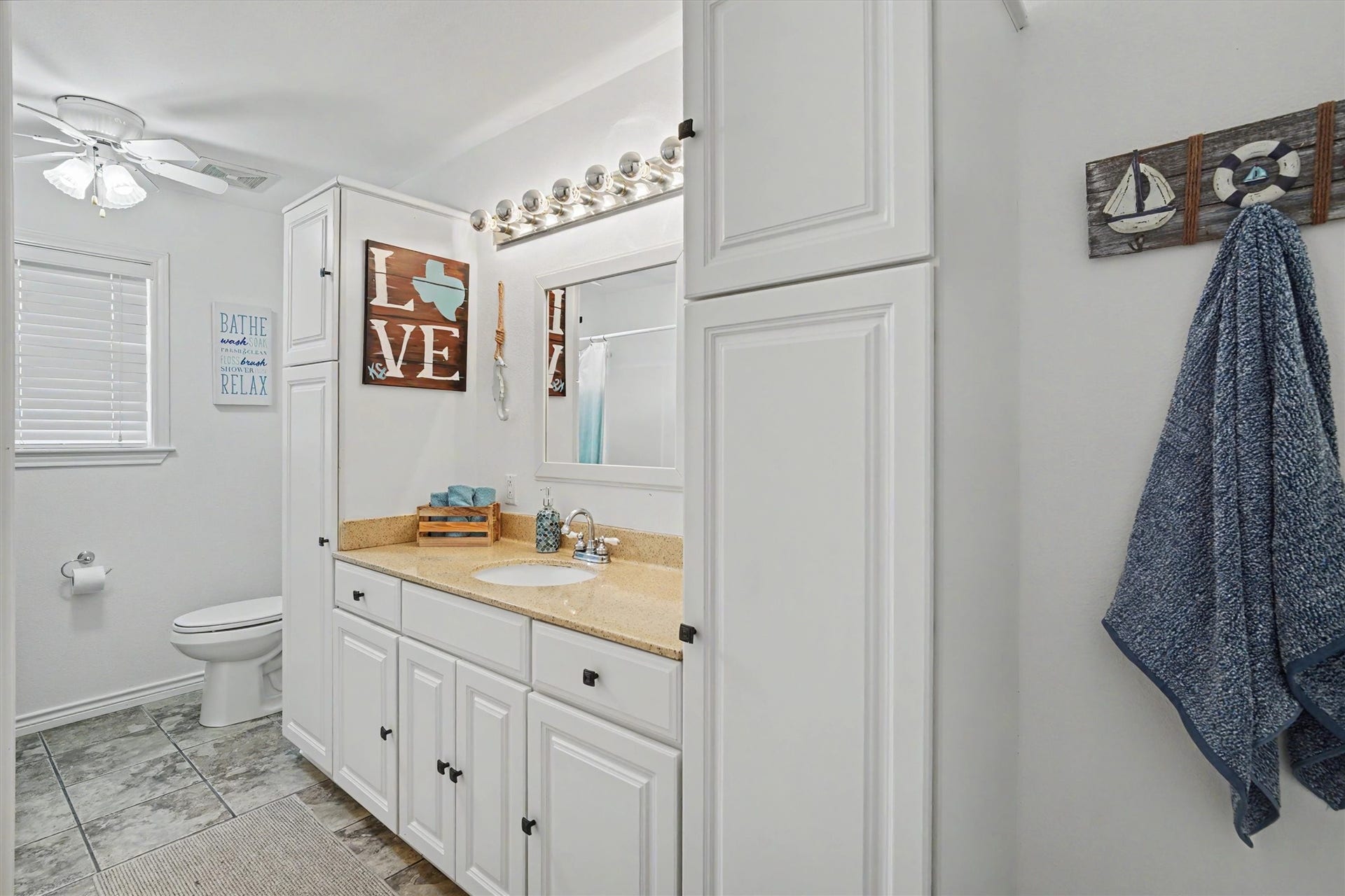 The guest bathroom has been updated with a solid surface countertop and lots of storage cabinets