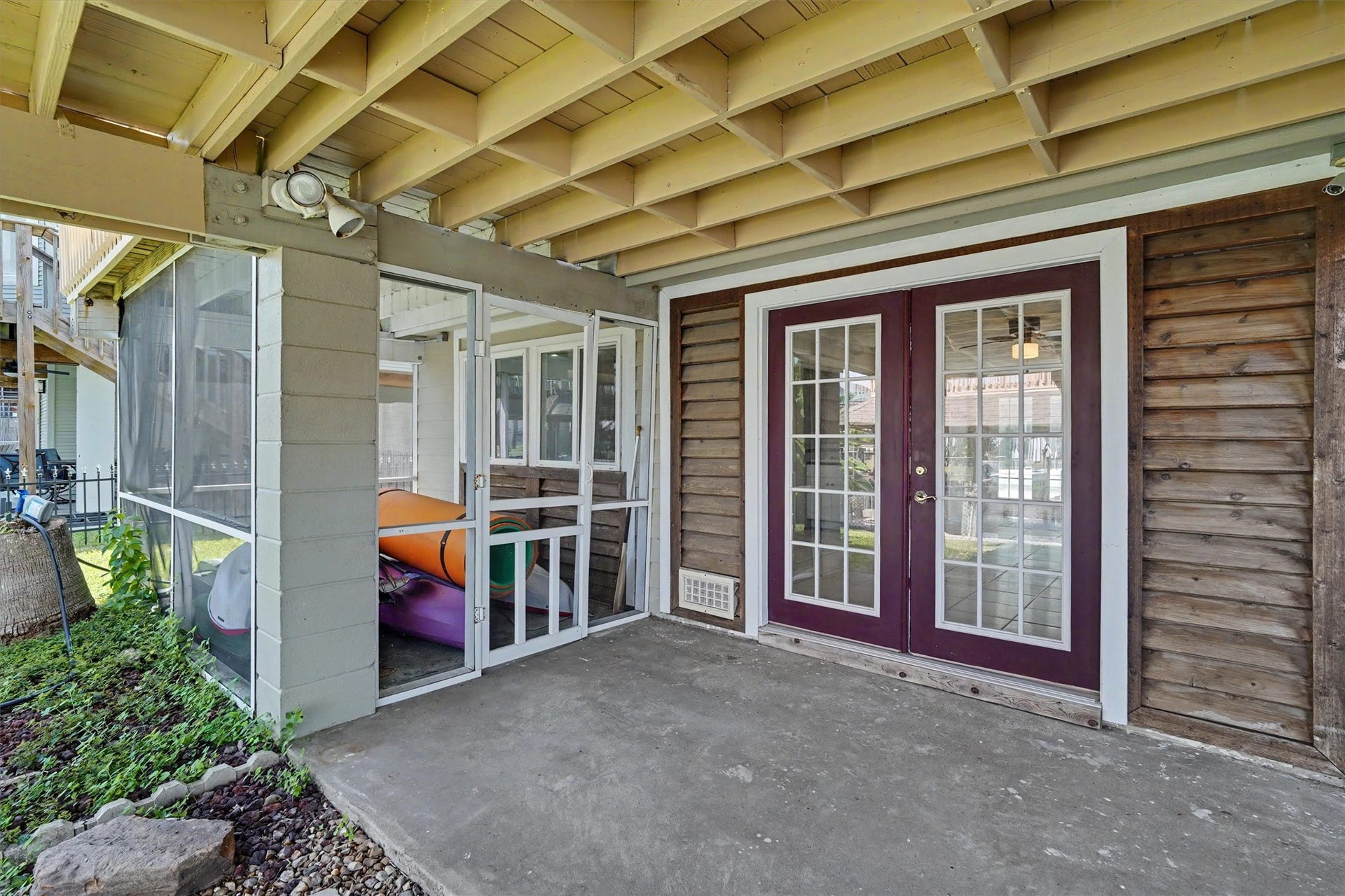 The screened-in porch is a nice seating area during the mosquito season, or could be used for storage. The french doors lead into the flex room downstairs