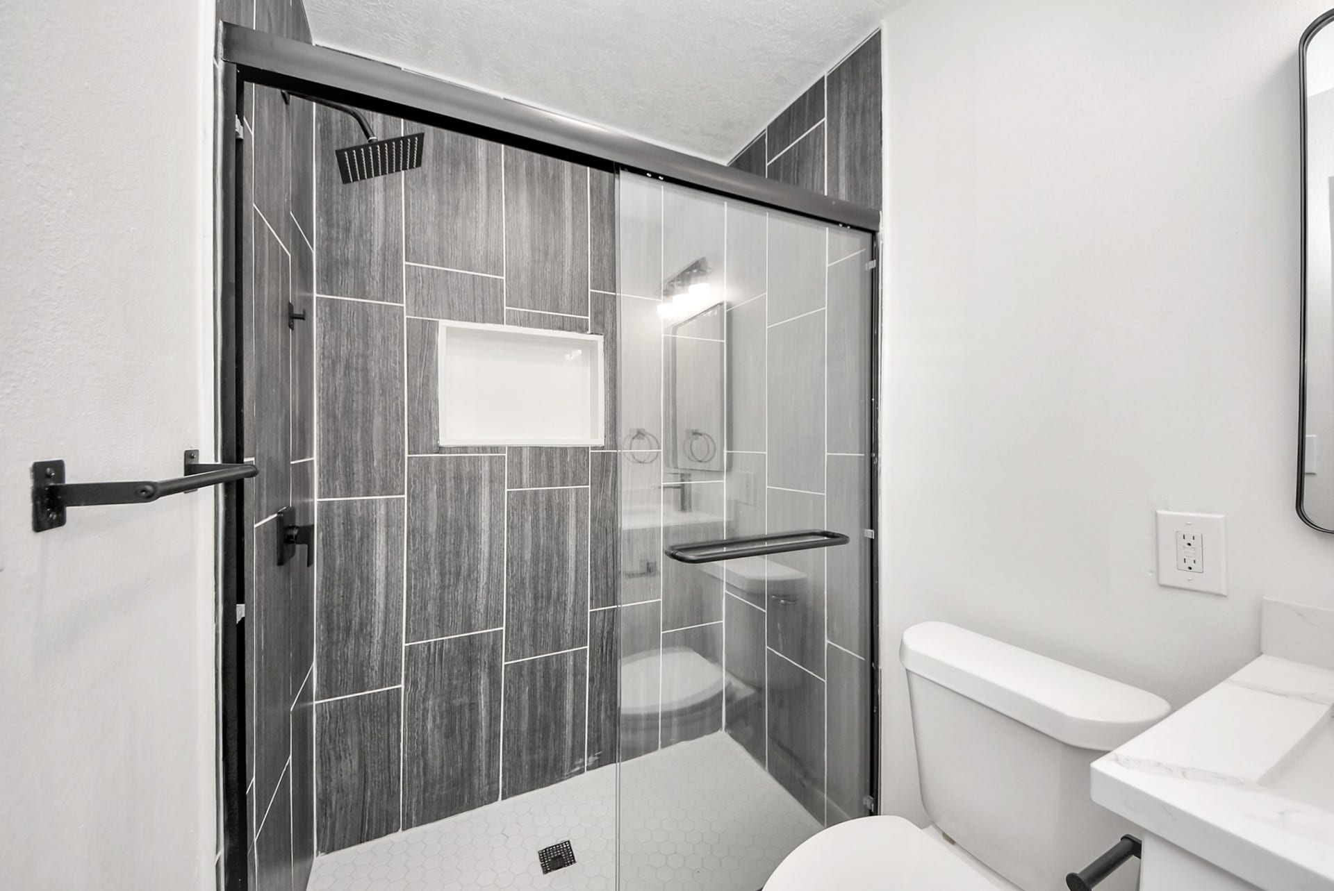9610 Westview Drive, Houston, TX 77055 A thoughtfully updated bathroom featuring a spacious walk-in shower, modern tilework, a glass shower enclosure, and a streamlined vanity area. Clean finishes and a bright layout create a fresh, inviting space.