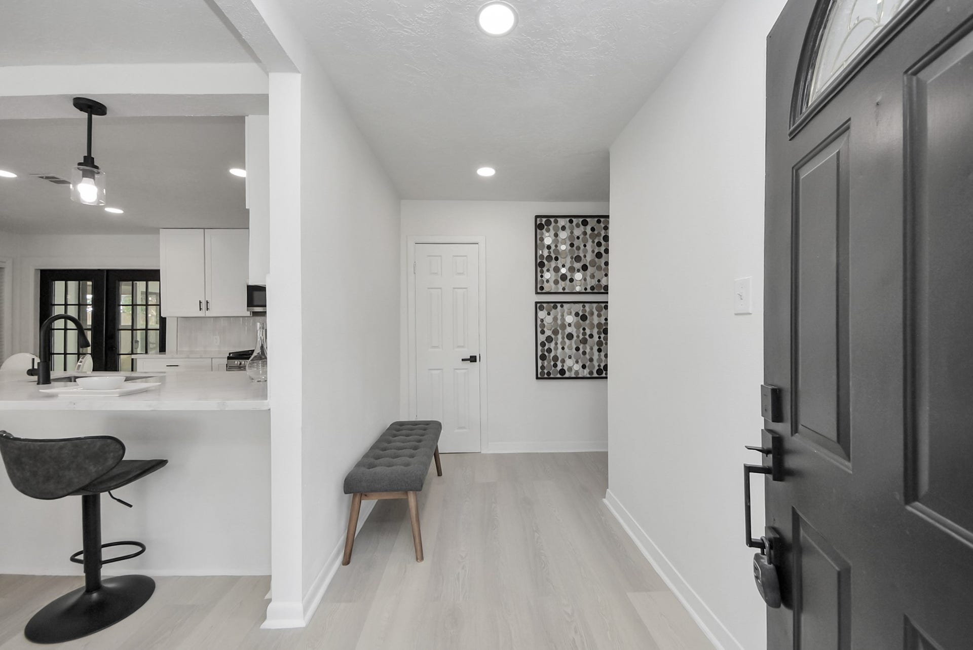 9610 Westview Drive, Houston, TX 77055 Inviting entryway leads to a bright, modern kitchen with sleek finishes and bar seating, perfect for casual dining.