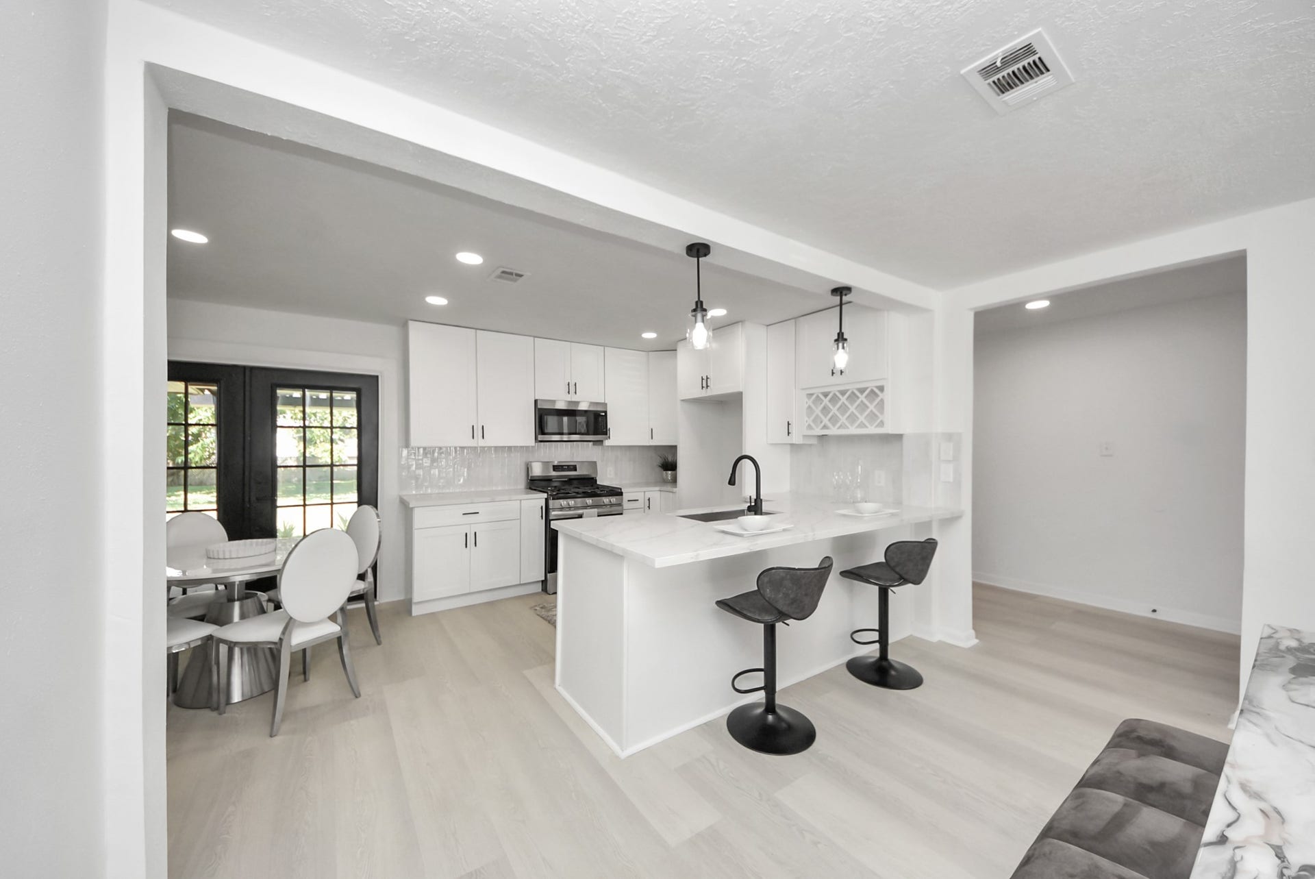 9610 Westview Drive, Houston, TX 77055 Designed for both functionality and style, this well-appointed kitchen features a spacious center island, ample cabinetry, and an efficient layout that provides a seamless connection to the adjoining dining area.