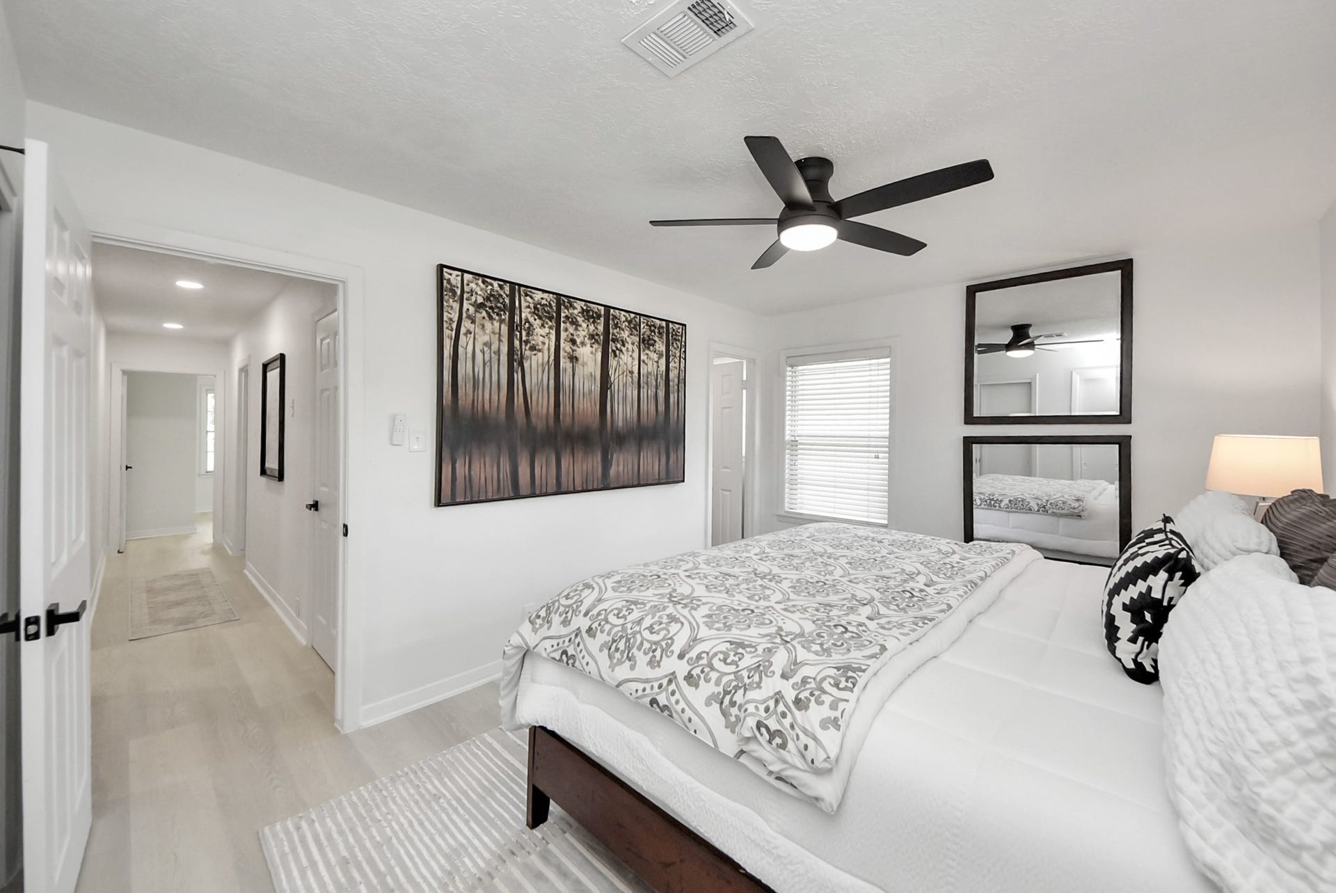 9610 Westview Drive, Houston, TX 77055 Bright and inviting bedroom featuring modern decor, a ceiling fan, and ample natural light, creating a cozy and stylish retreat.