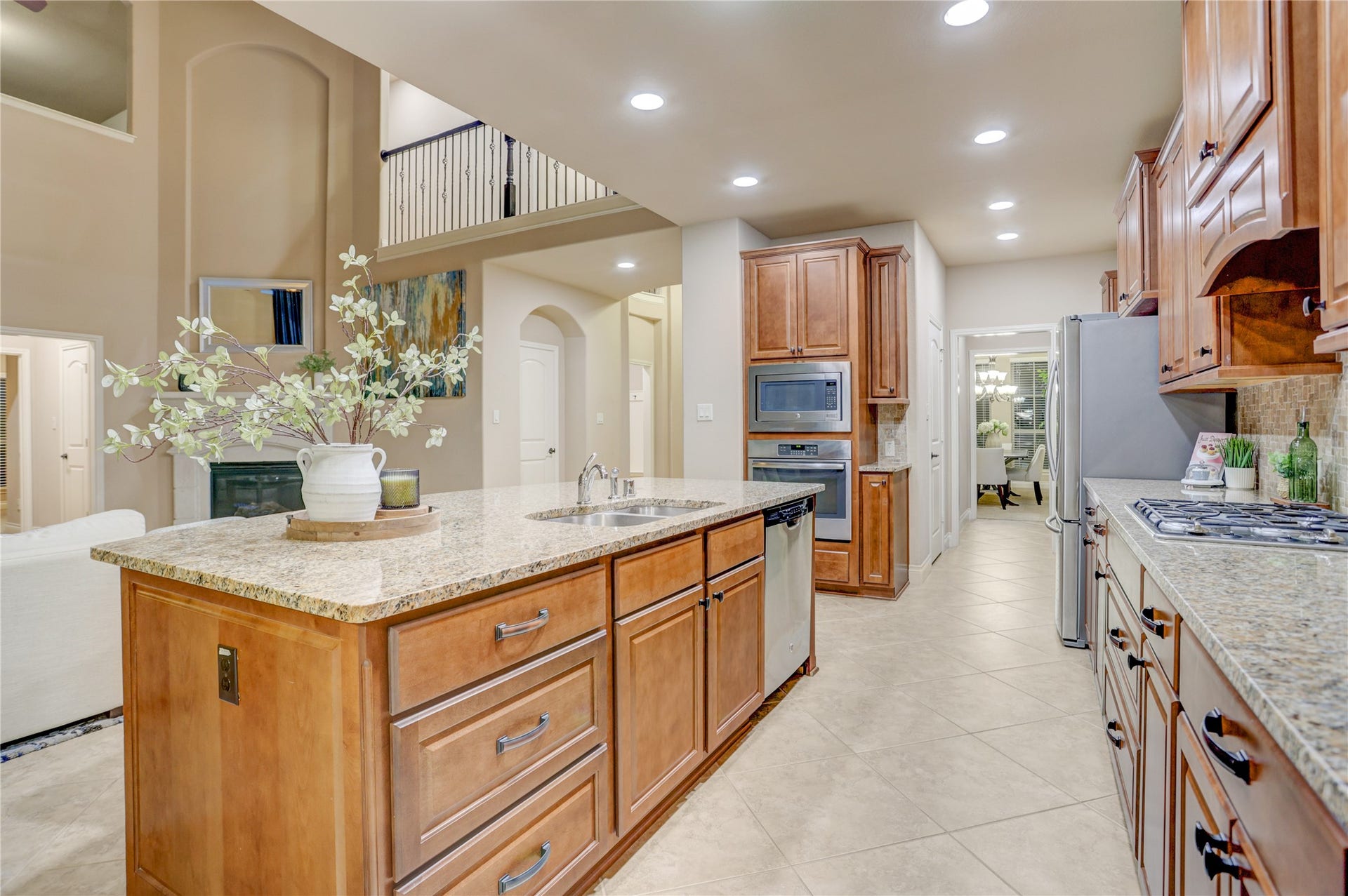13308 Paxton Hill Court, Pearland, TX 77584 A beautifully appointed kitchen combines timeless finishes with exceptional functionality, featuring rich wood cabinetry, granite countertops, stainless steel appliances, a gas cooktop, and a spacious island designed for gathering and entertaining.