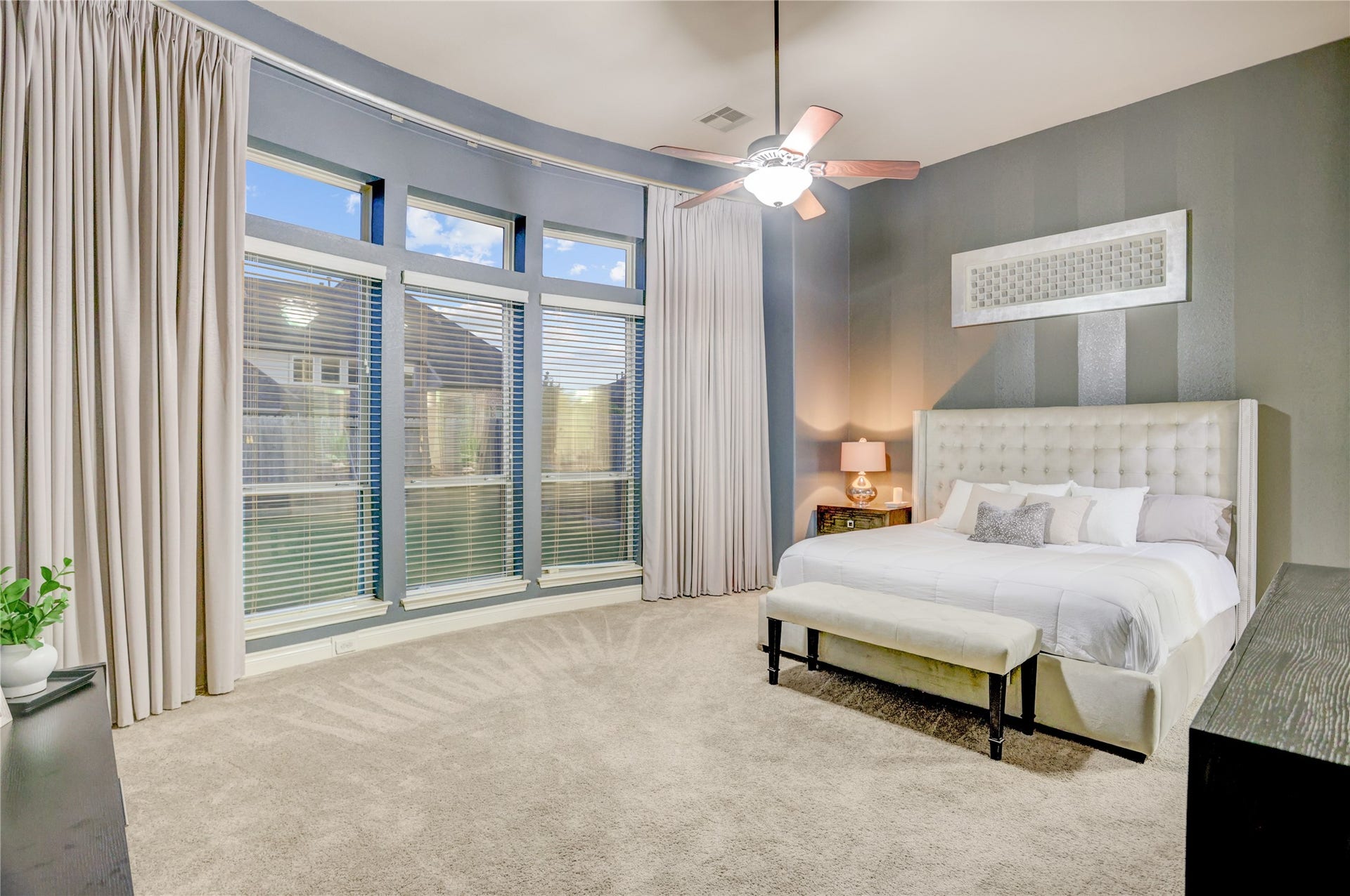 13308 Paxton Hill Court, Pearland, TX 77584 Retreat to the spacious primary suite featuring a stunning curved wall of windows, soaring ceilings, and abundant natural light. This private sanctuary offers generous space for a sitting area while creating a bright, relaxing atmosphere to unwind at the end of the day.