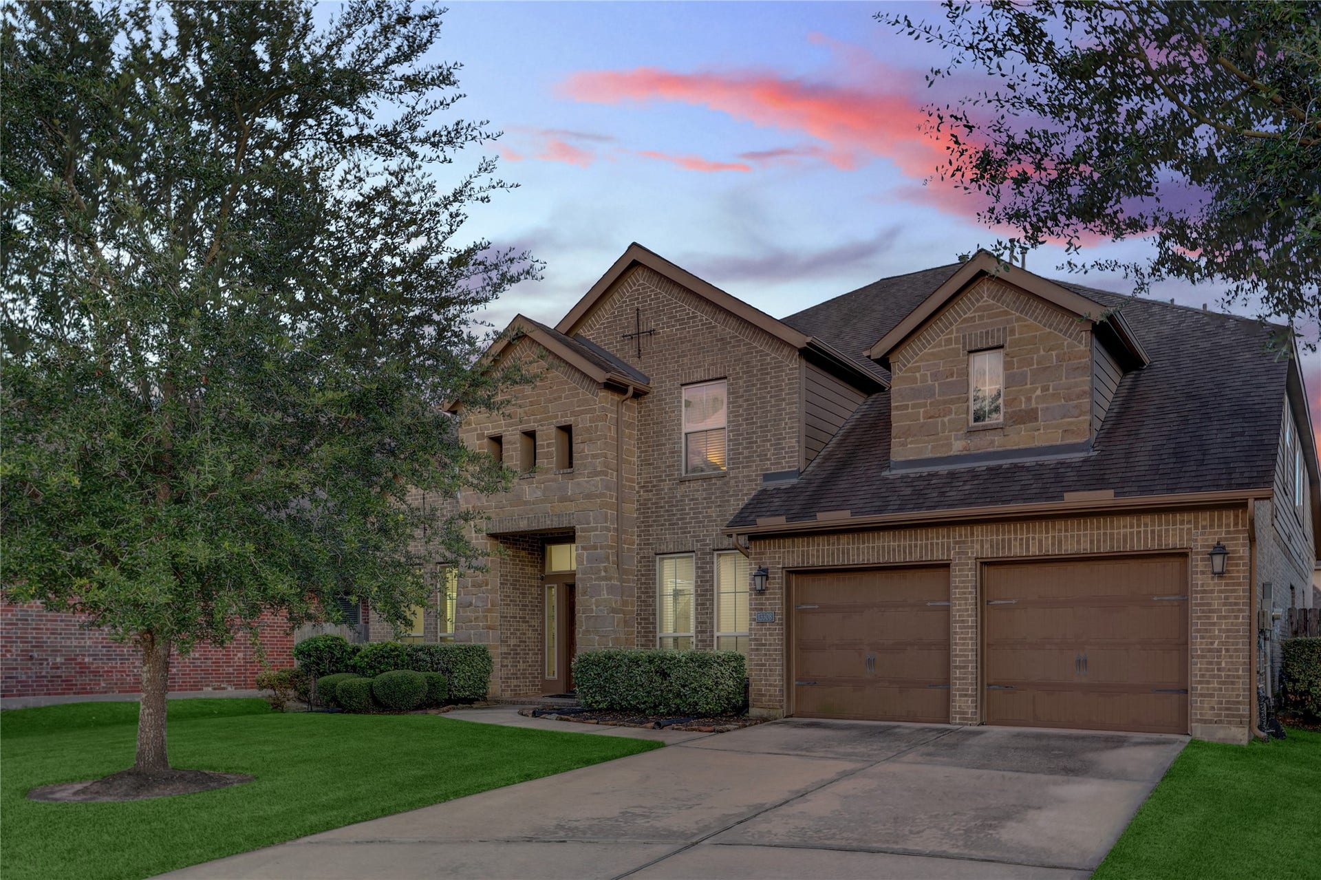 13308 Paxton Hill Court, Pearland, TX 77584 Beautiful brick and stone exterior featuring a covered front porch, manicured landscaping, and a 3-car garage with ample parking and storage.