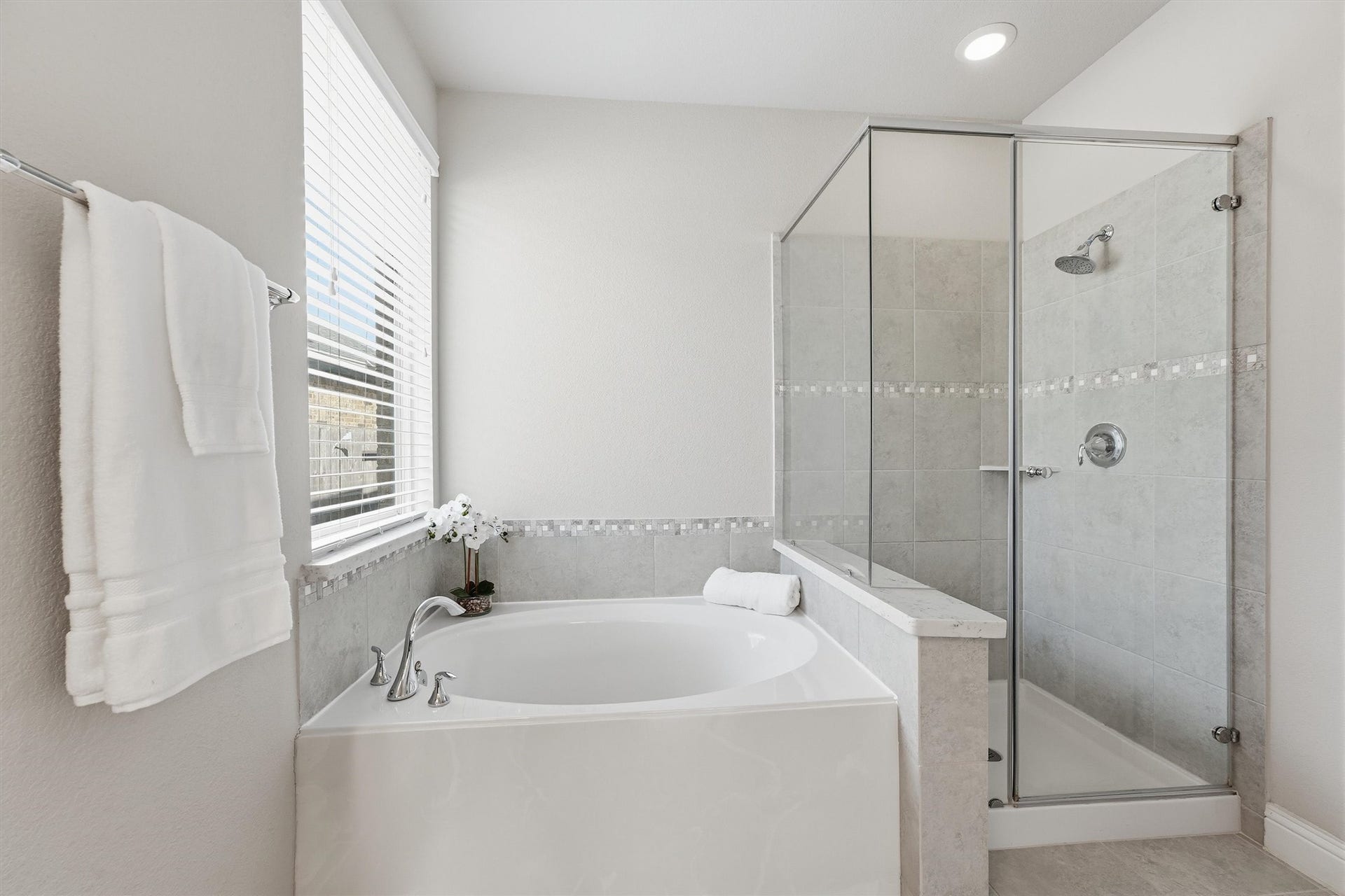 31549 Timber Grove Lane, Spring, TX 77386 Primary bath with a soaking tub, separate glass-enclosed shower and decorative tile accents.