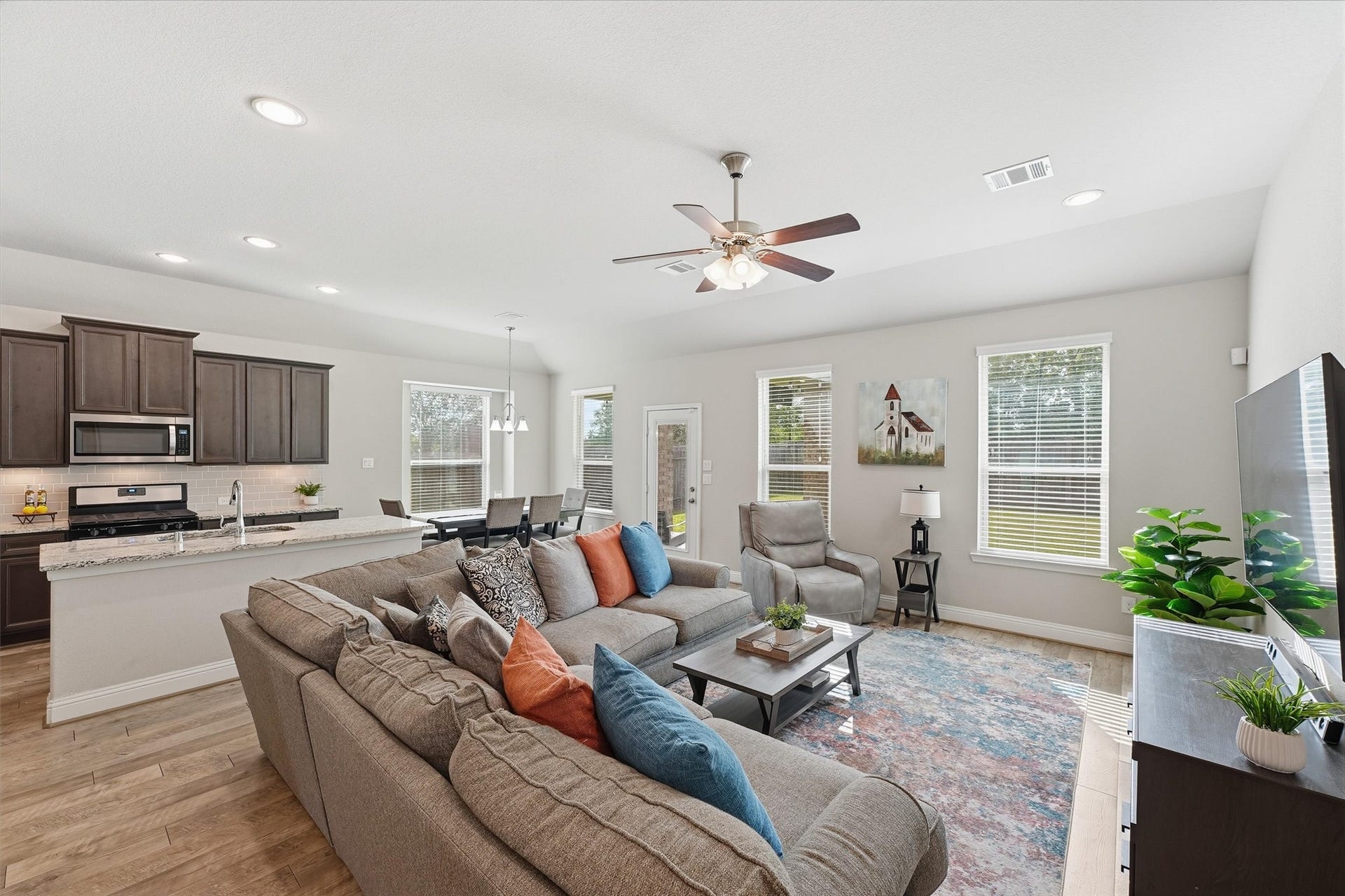 31549 Timber Grove Lane, Spring, TX 77386 Light-filled family room with high ceilings and an open connection to the kitchen and dining area.