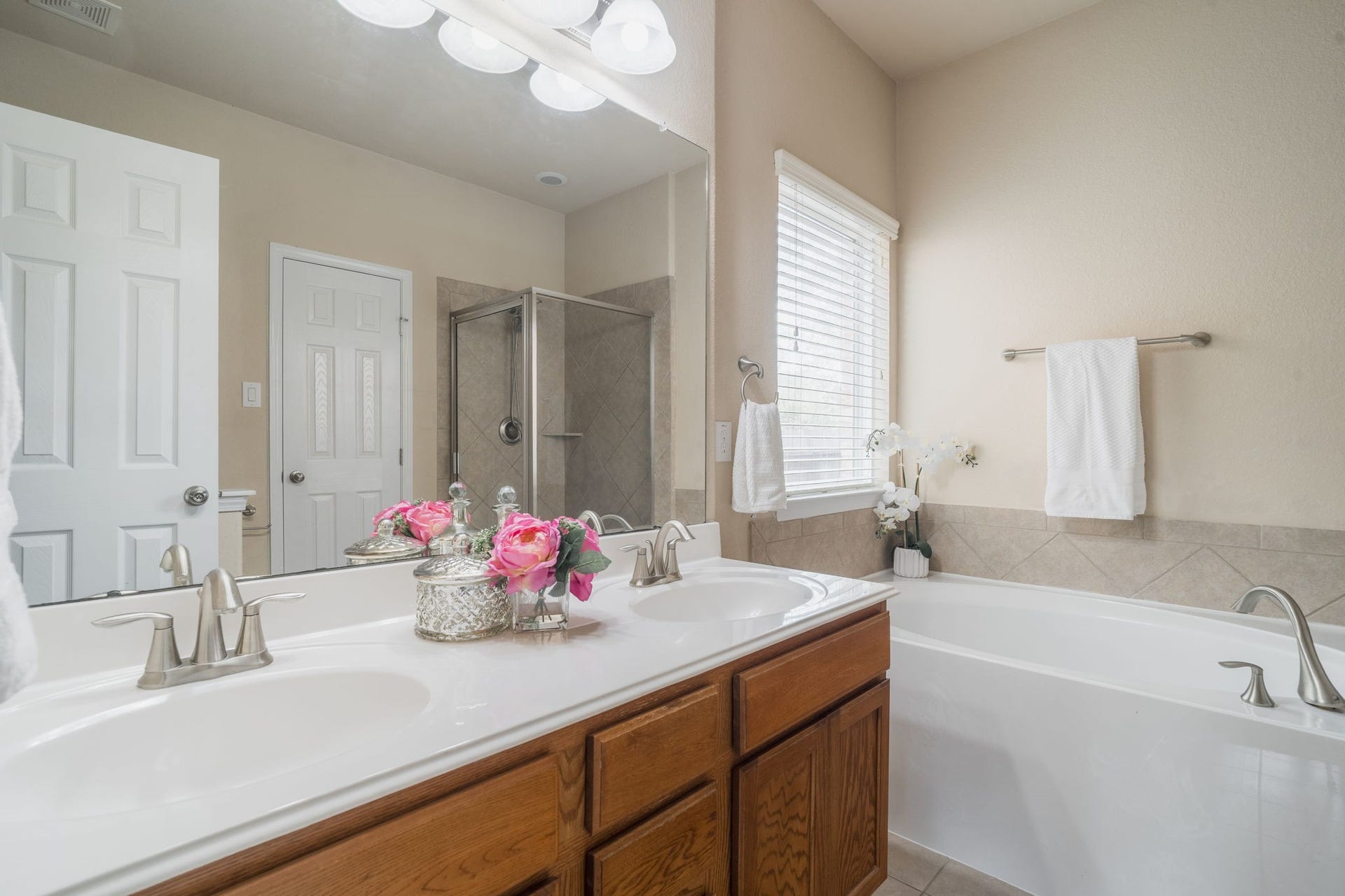 7222 Stevenson Drive, Missouri City, TX 77459 Primary en-suite bath featuring dual vanities, a soaking tub & a separate glass-enclosed shower with tile surround.