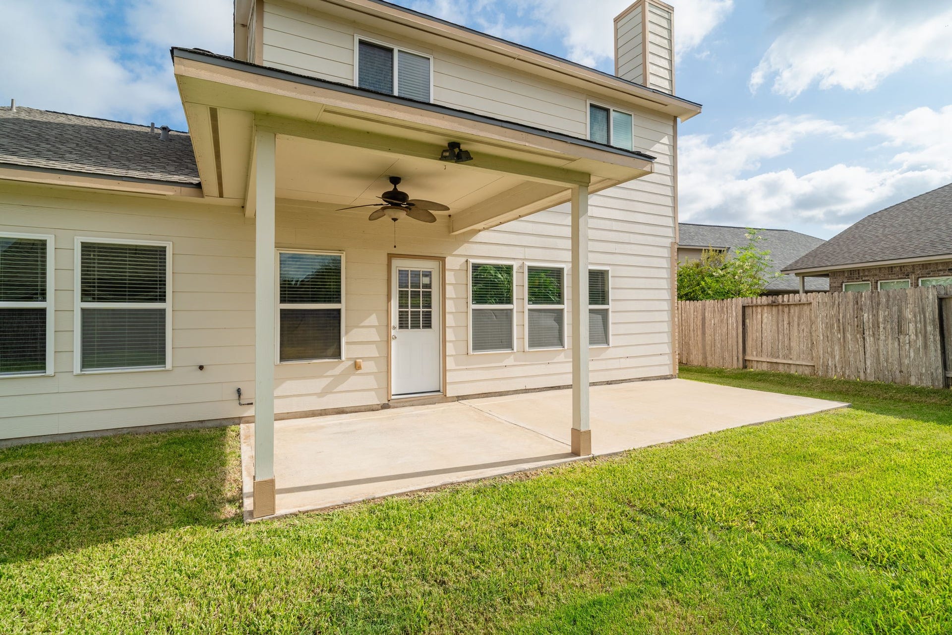 7222 Stevenson Drive, Missouri City, TX 77459 Generously sized covered patio with ceiling fan & an extended concrete area, offering flexibility for outdoor dining & seating.