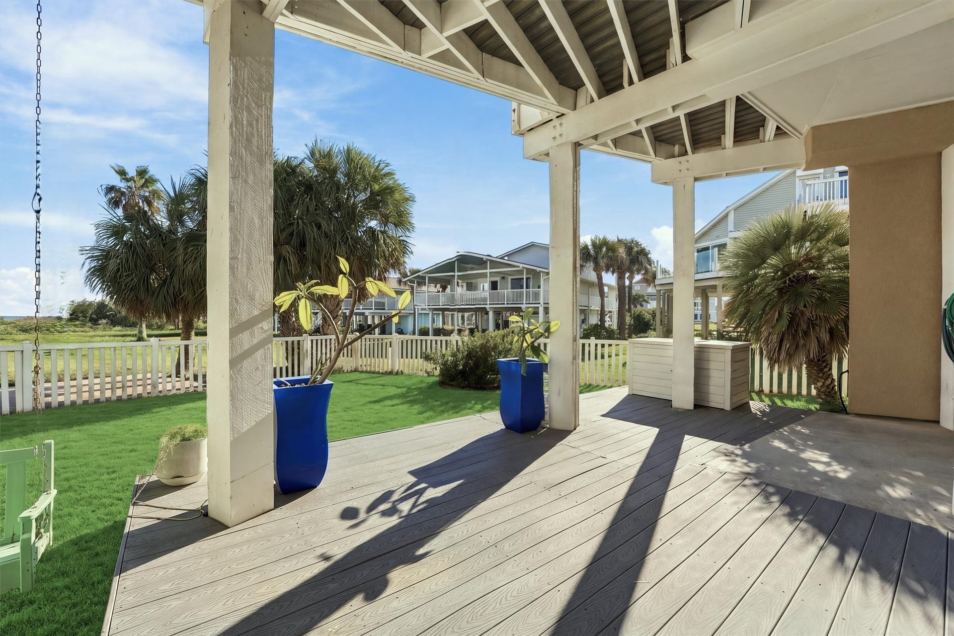 4207 Barataria Court, Galveston, TX 77554 Step into the shade and enjoy a quiet moment overlooking the fenced lawn. Potted plumerias and surrounding palms bring tropical charm to this covered outdoor retreat, with the beach just steps away.