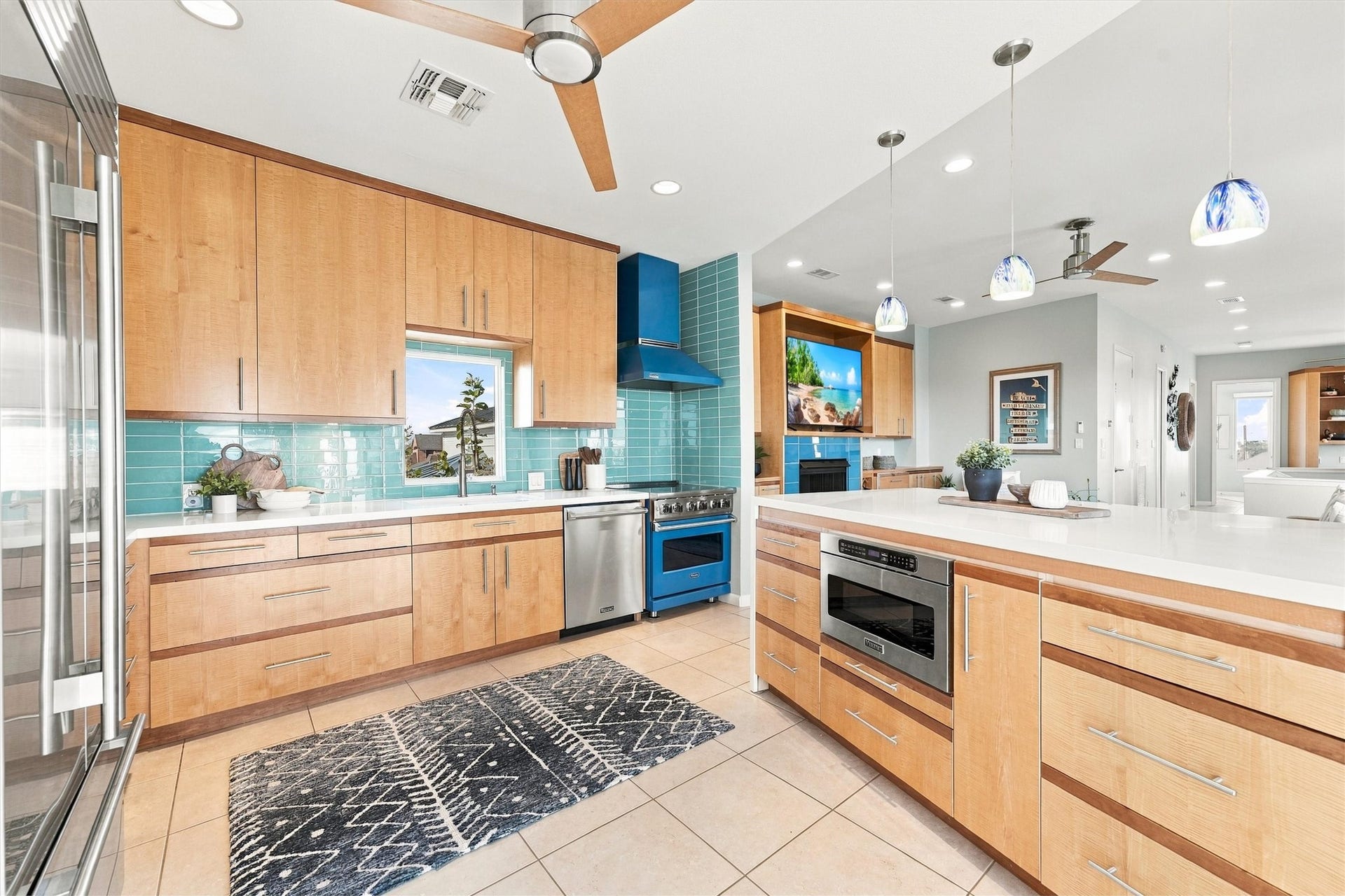 4207 Barataria Court, Galveston, TX 77554 Gather around the generous kitchen counter. A striking blue range, sea-glass-colored backsplash, and warm wood cabinetry make preparing meals part of the coastal experience.