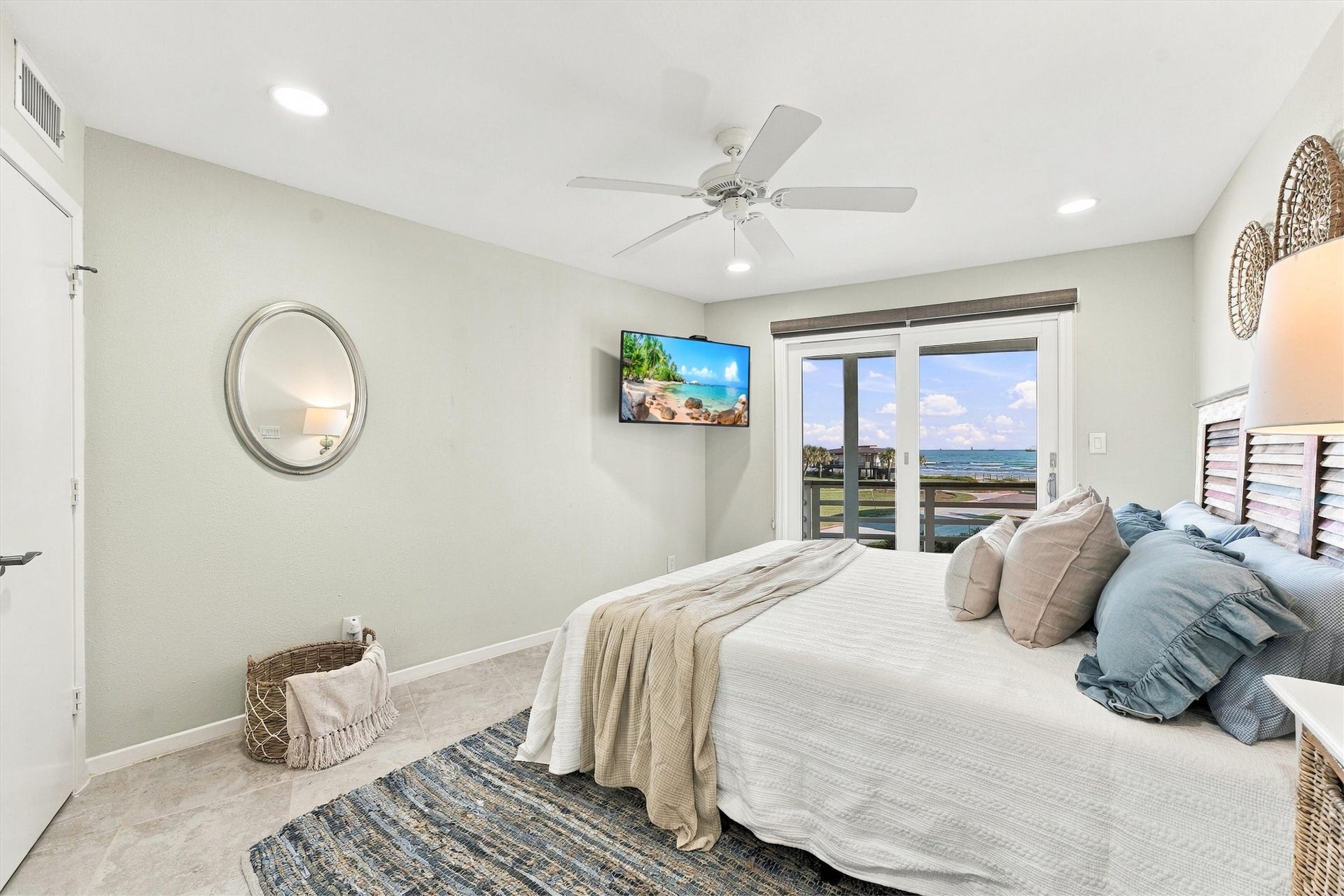 4207 Barataria Court, Galveston, TX 77554 This inviting bedroom offers soothing coastal colors and direct balcony access, making morning coffee with a beach view an everyday pleasure.