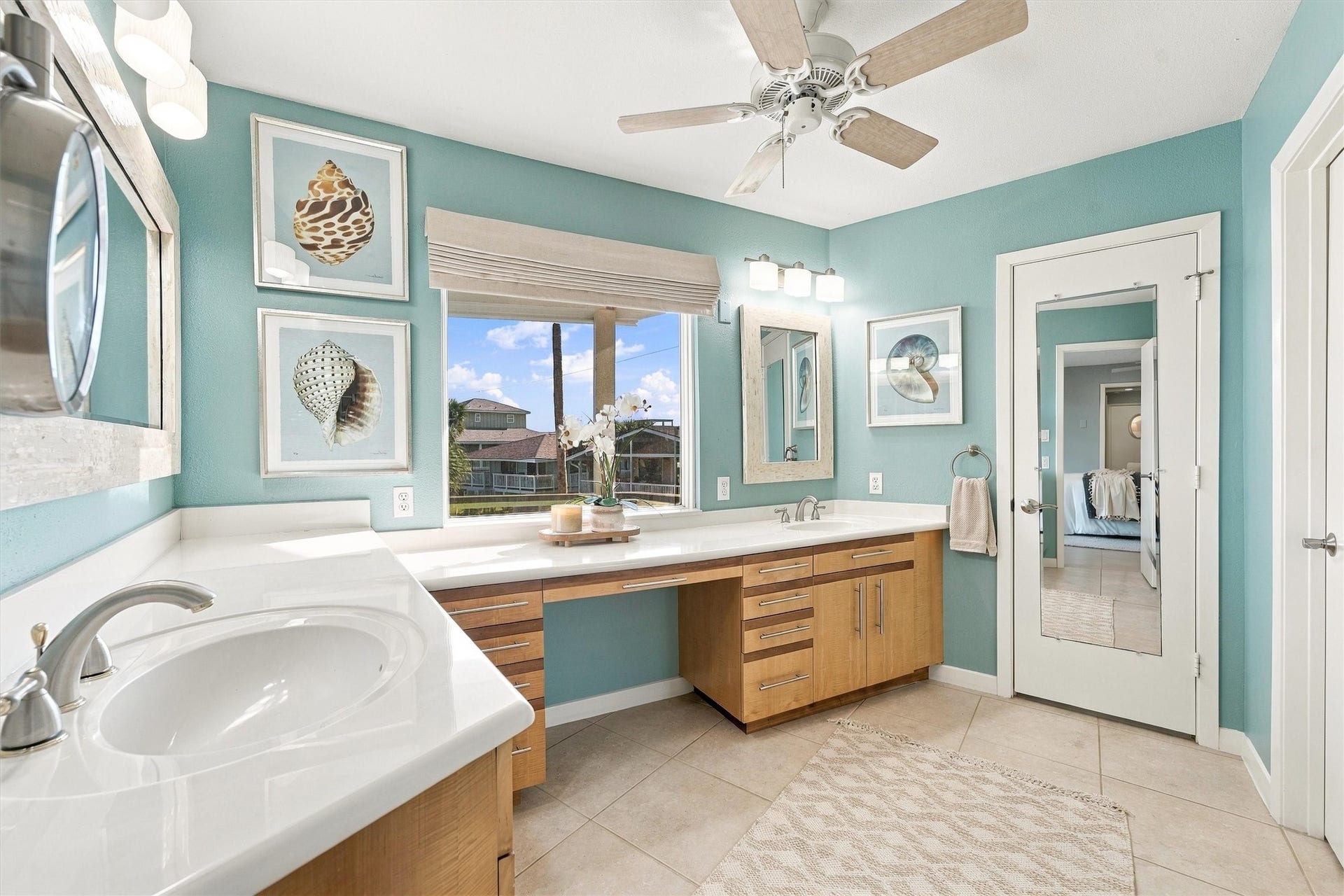 4207 Barataria Court, Galveston, TX 77554 A refreshing retreat of seafoam walls, crisp white counters, and warm wood cabinetry. Expansive vanities give everyone room to get ready for an evening out.