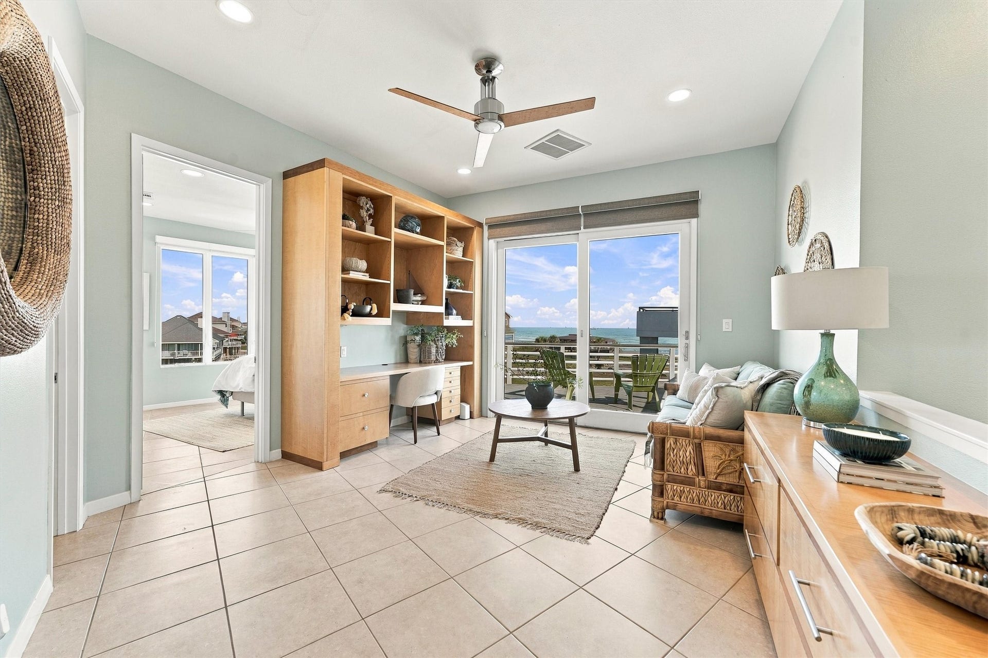 4207 Barataria Court, Galveston, TX 77554 A little work, a little daydreaming, and a beautiful beach view. This bright study pairs a built-in desk and shelving with a comfortable sitting area, while sliding glass doors lead outside for a refreshing balcony break.