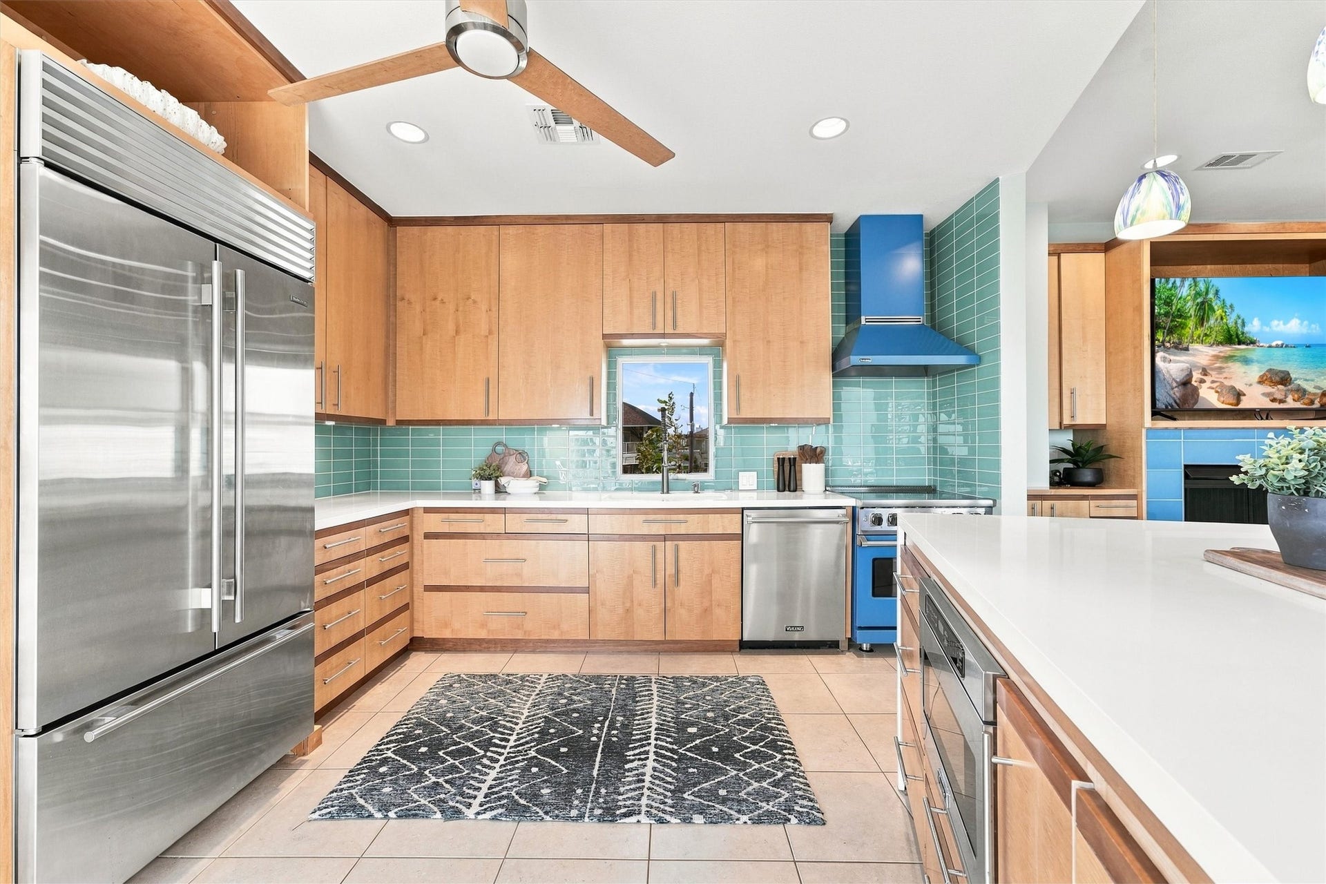 4207 Barataria Court, Galveston, TX 77554 Let the island inspire your next meal. A bold blue range and matching hood complement the seafoam backsplash, while expansive white counters provide plenty of room to prepare, serve, and gather.