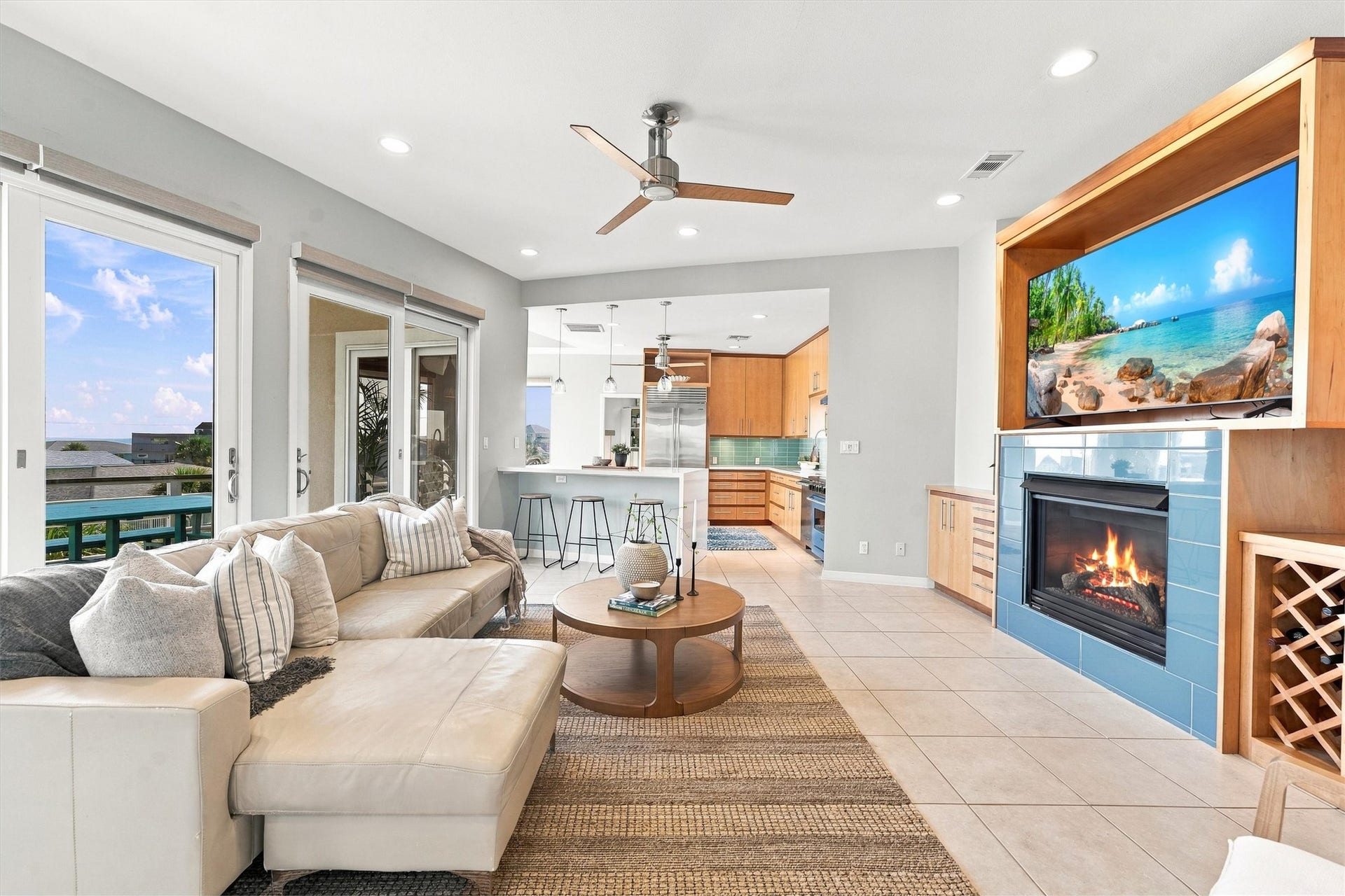 4207 Barataria Court, Galveston, TX 77554 Spend the afternoon by the water, then settle into this light-filled living area. A blue-tiled fireplace adds warmth, while sliding glass doors connect the gathering space to balcony dining and coastal views.