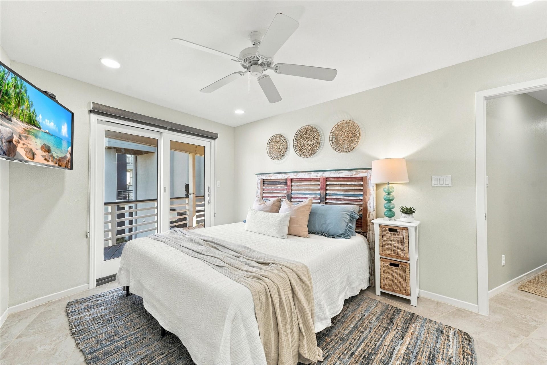 4207 Barataria Court, Galveston, TX 77554 After a day along the shore, retreat to a restful bedroom filled with coastal charm. Soft blues, woven textures, and sliding glass doors to the covered balcony create a welcoming place to unwind.