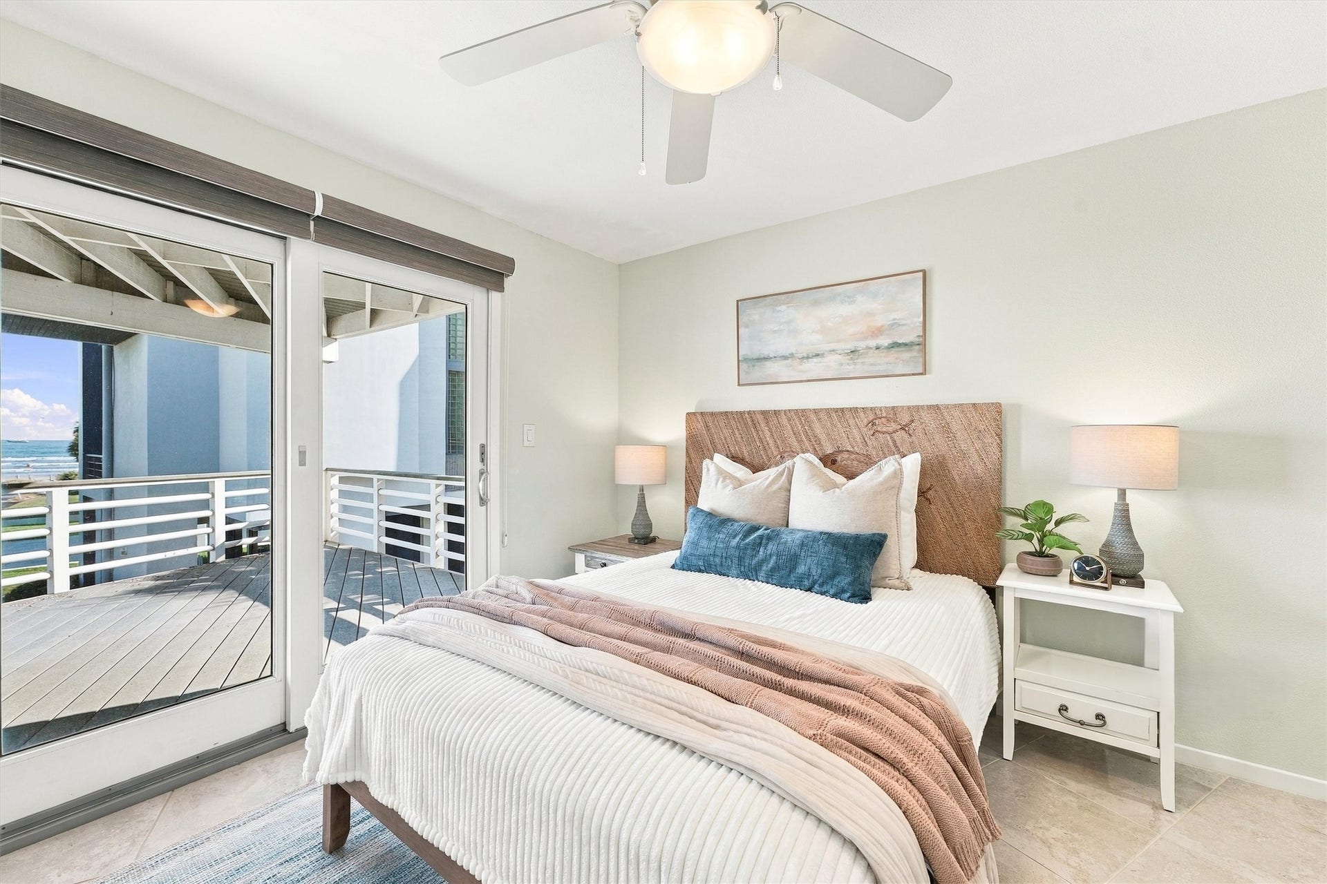 4207 Barataria Court, Galveston, TX 77554 Slide open the doors and ease into island time. This restful bedroom pairs soft coastal tones with covered balcony access and a glimpse of the waves beyond.