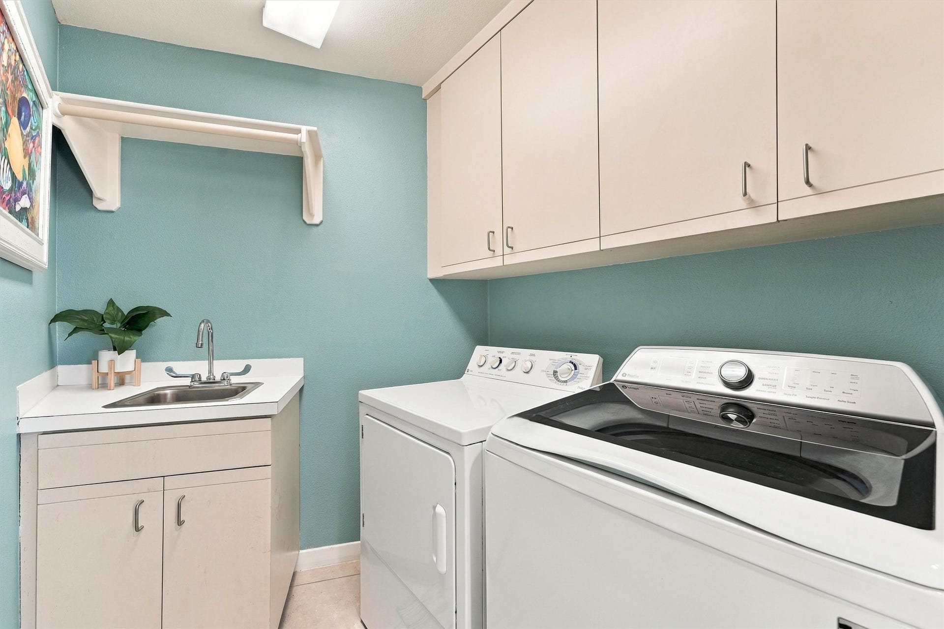4207 Barataria Court, Galveston, TX 77554 Keep beach towels fresh and swimsuits ready for another day by the water. This dedicated laundry room features a washer and dryer, utility sink, overhead cabinetry, and a hanging rod for everyday convenience.