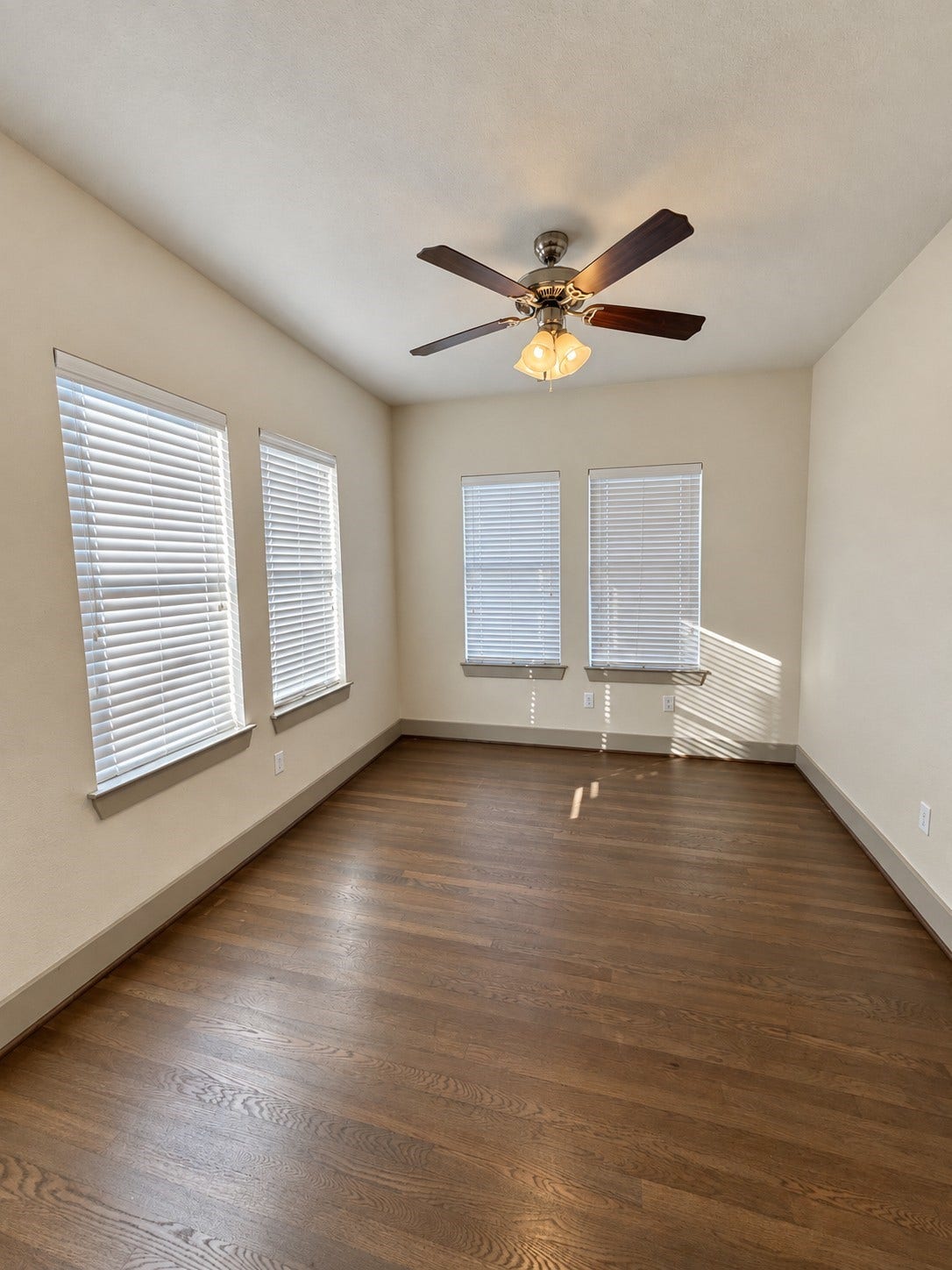 1660 Hawthorne Street, Houston, TX 77006 Representative unit bedroom. Light-filled bedroom within one of the eight units, featuring wood flooring, ceiling fan, and multiple windows providing natural light.
