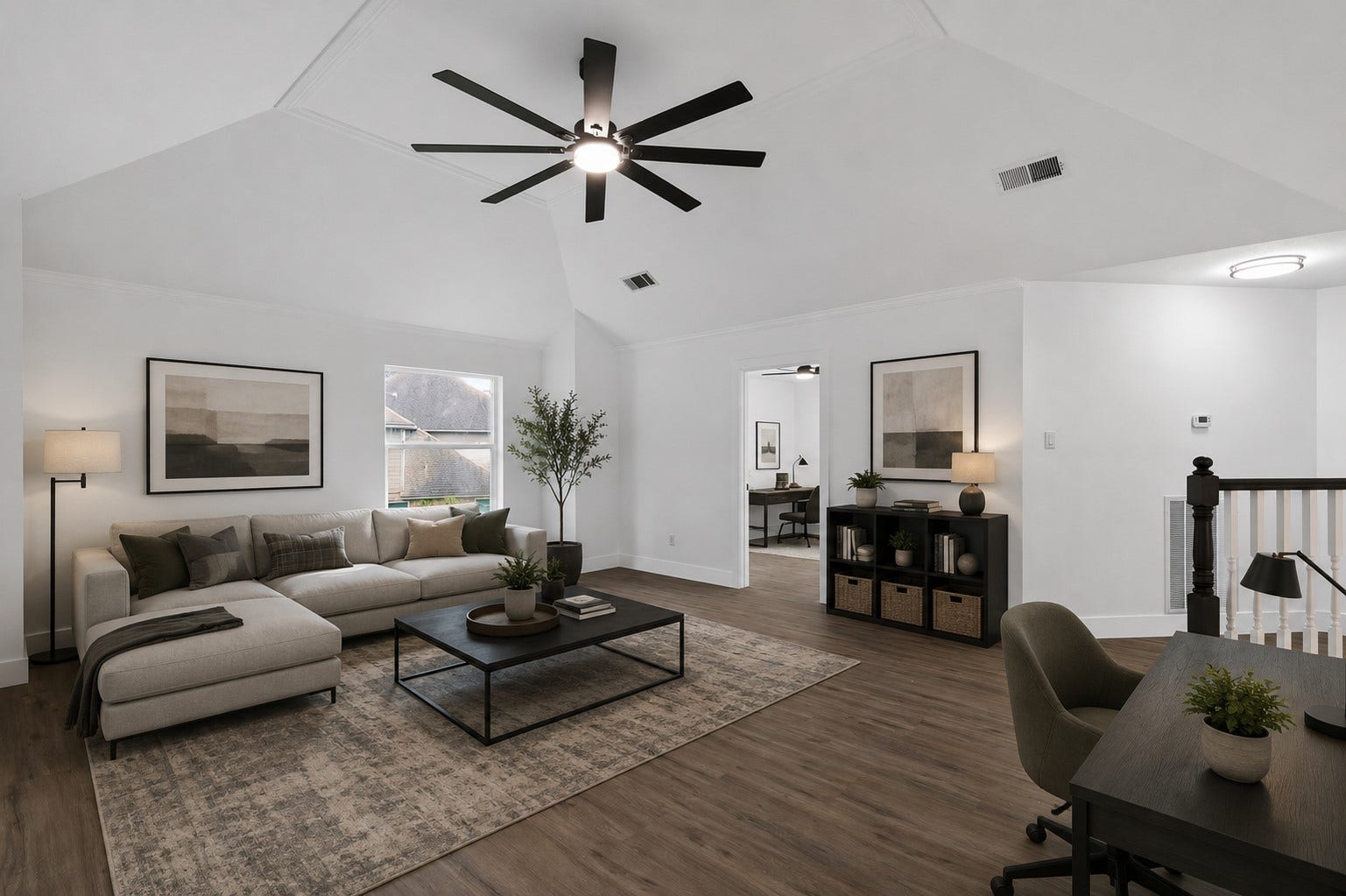 523 Rampart Lane, Conroe, TX 77302 Spacious living area on second floor with vaulted ceilings, modern ceiling fan, and abundant natural light. Ready to create a perfect blend of comfort and functionality. Photo digitally staged.