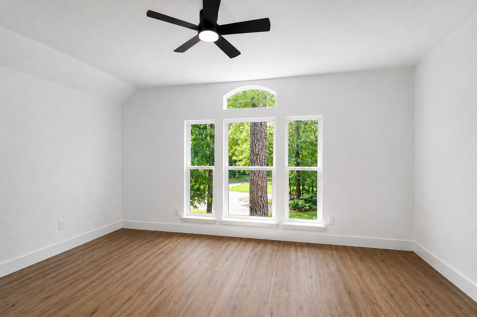 523 Rampart Lane, Conroe, TX 77302 Secondary bright and airy room featuring large windows with scenic views, elegant vinyl flooring, and a modern ceiling fan.