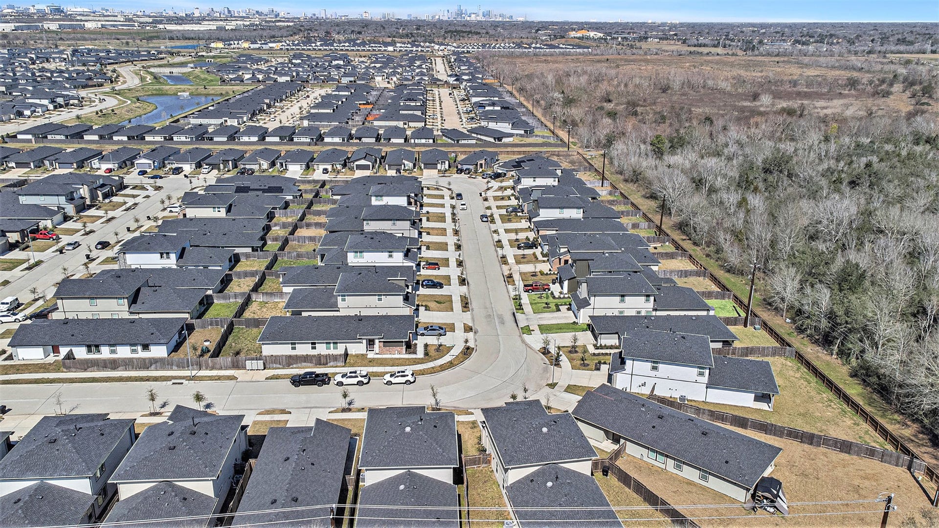 Aerial view of the surrounding neighborhood with the Houston skyline visible in the distance, highlighting the homes convenient location near the city. Photo taken prior to the addition of the deck and pergola.