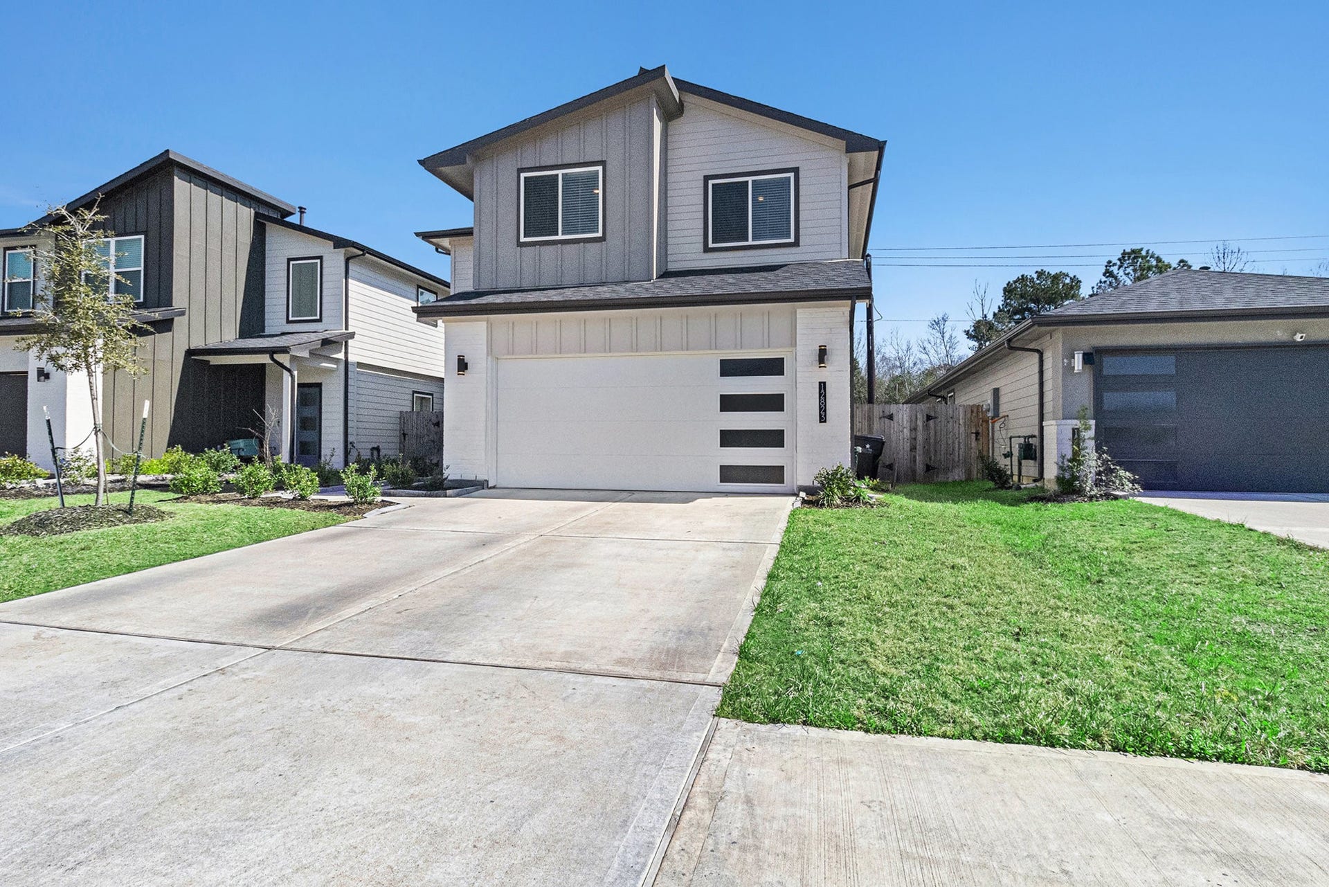 Contemporary curb appeal with clean architectural lines, attractive landscaping, and an attached two-car garage.