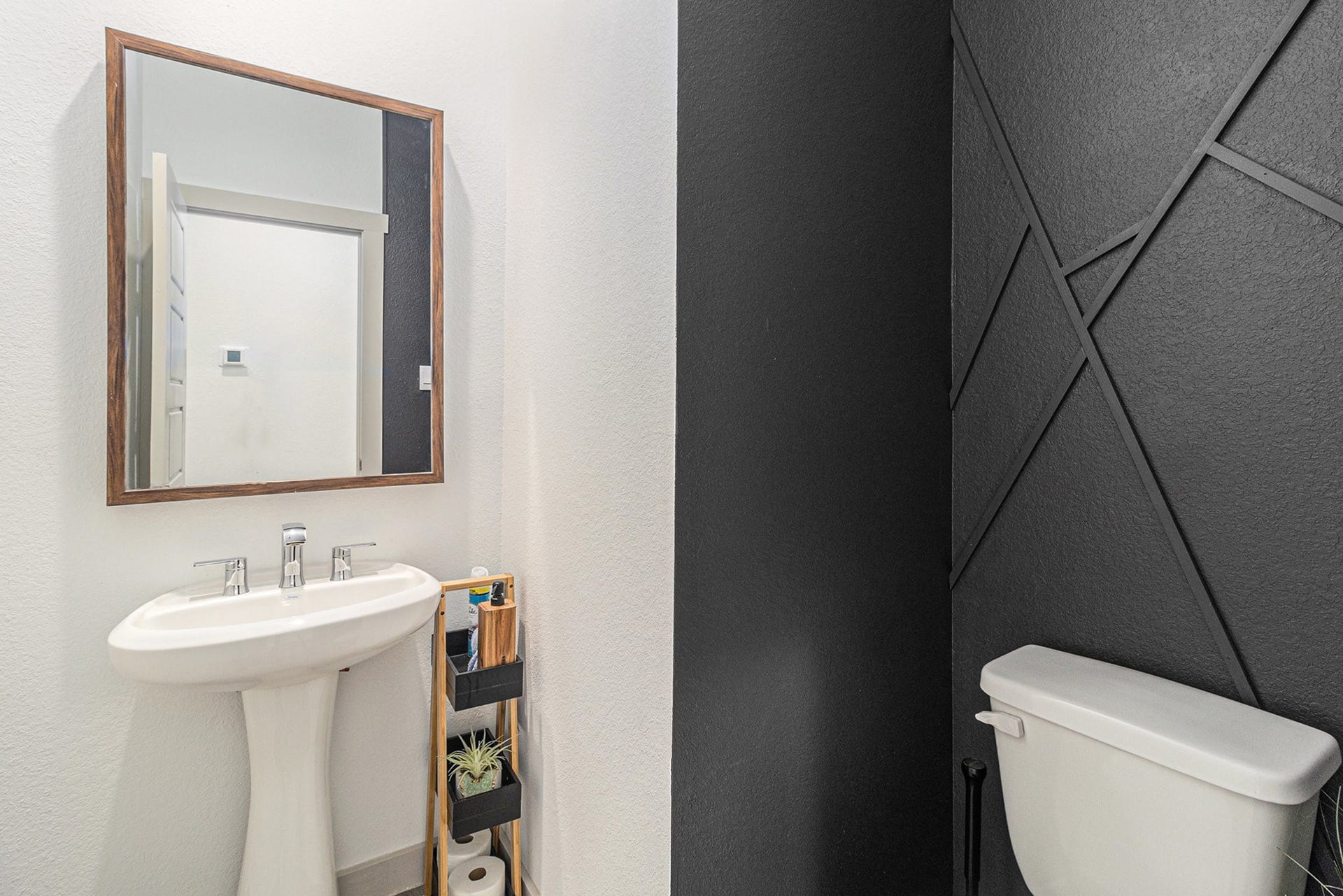 Discover a stylish and convenient downstairs half bath with modern design elements and a sleek pedestal sink, perfect for welcoming guests.