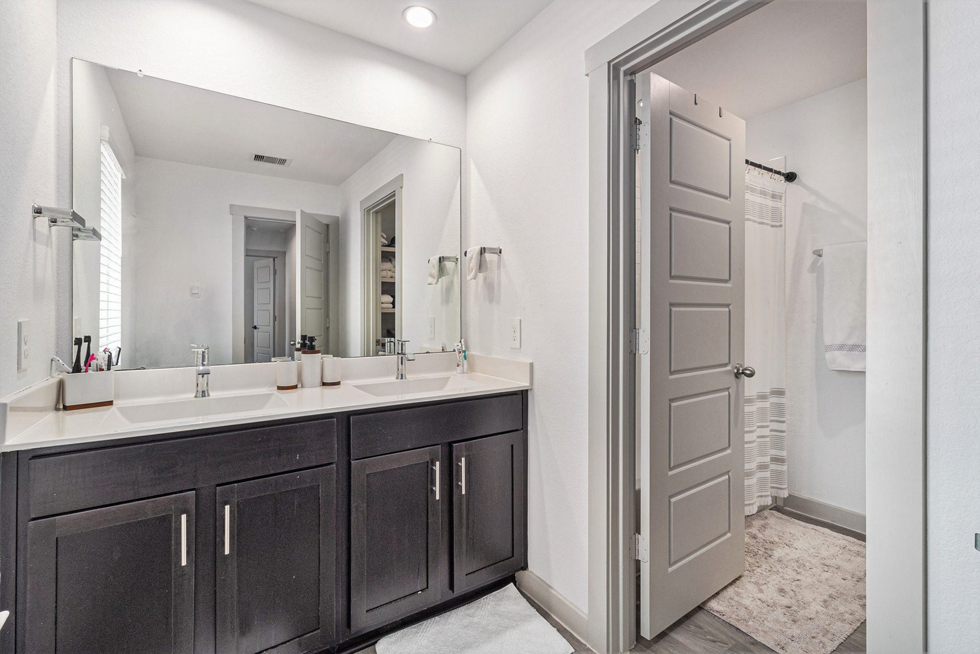 Spacious upstairs bathroom featuring a double-sink vanity, generous counter space, and a separate tub/shower area.