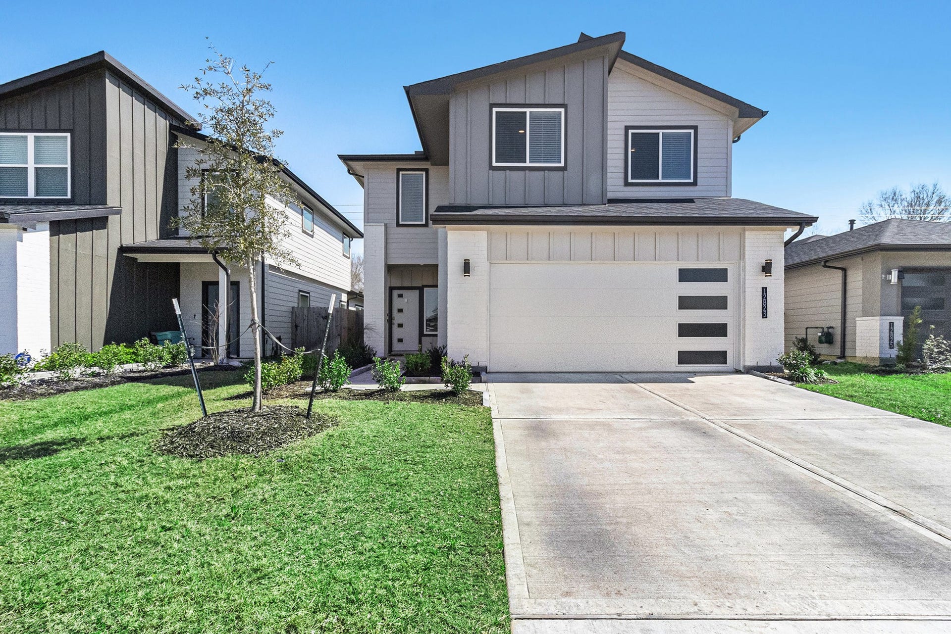 Another view of the home's modern exterior, private driveway, and two-car garage.