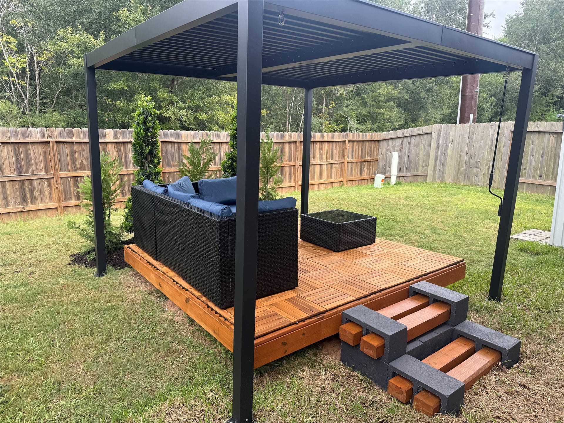 Spacious backyard retreat featuring a newly added raised deck, modern pergola and outdoor seating area. Wood-look deck tiles continue onto the covered patio for an updated, cohesive outdoor space.
