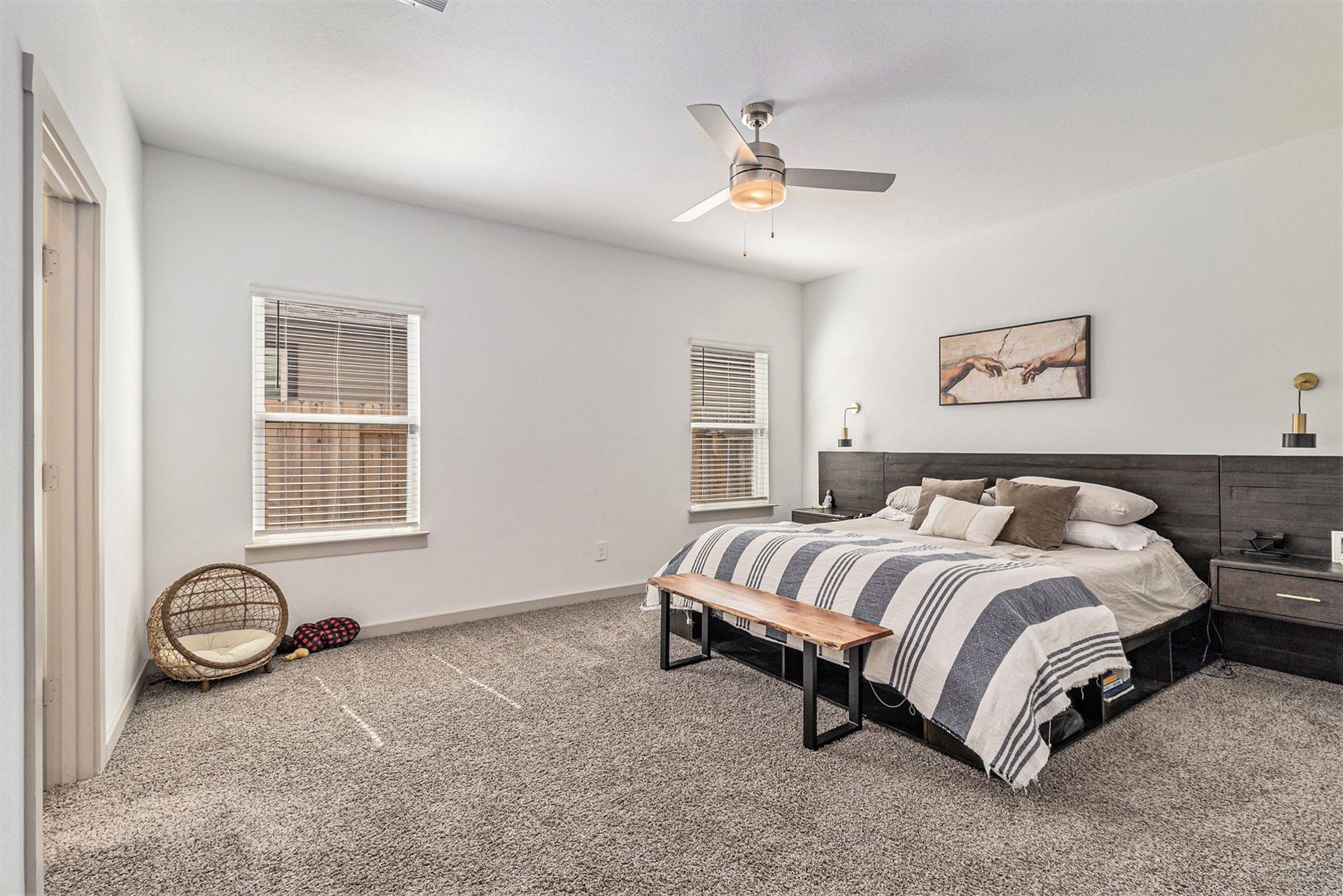 Spacious first-floor primary suite with abundant natural light, neutral finishes, and plenty of room for a king-size bedroom arrangement.