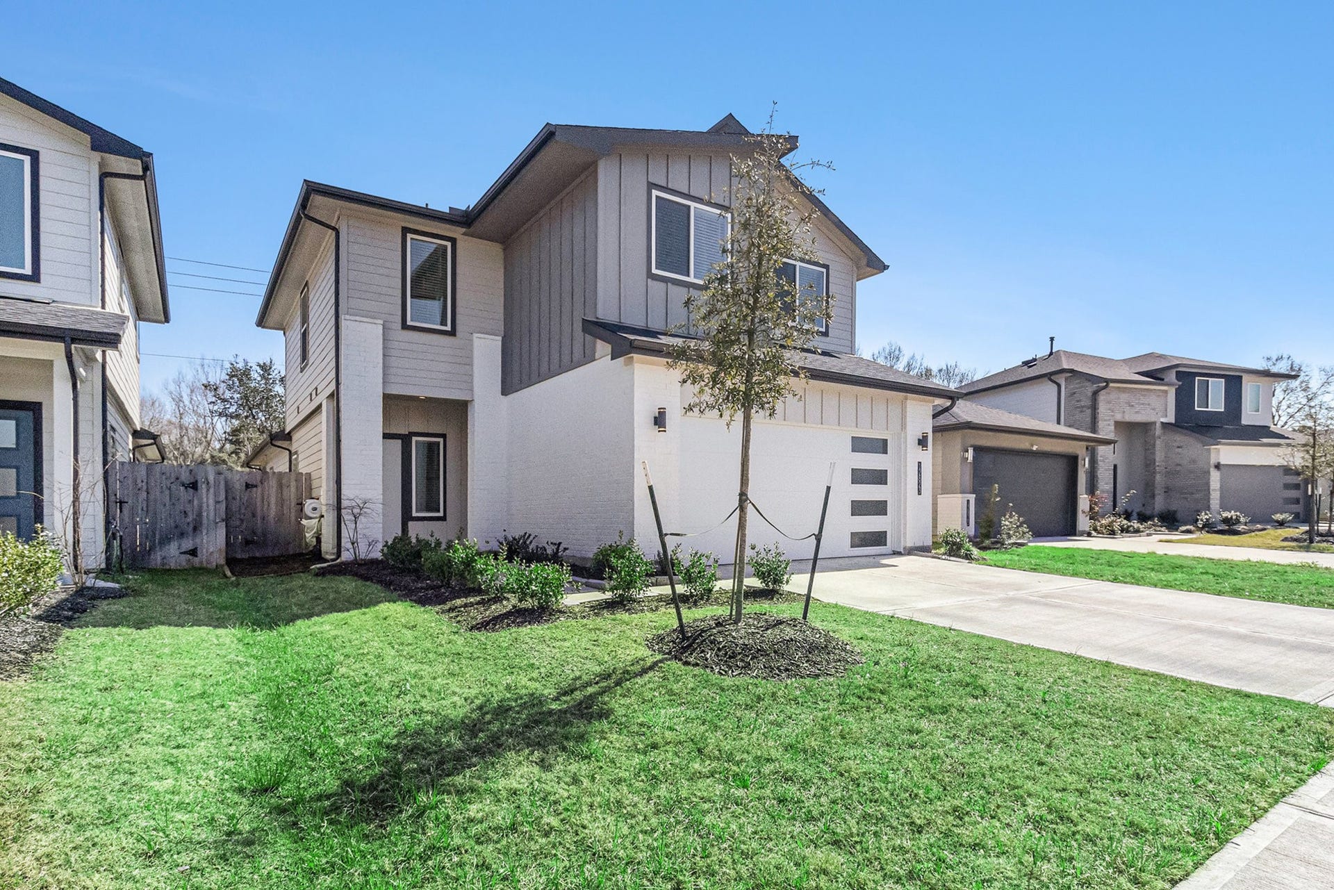 Contemporary curb appeal with clean architectural lines, attractive landscaping, and an attached two-car garage.
