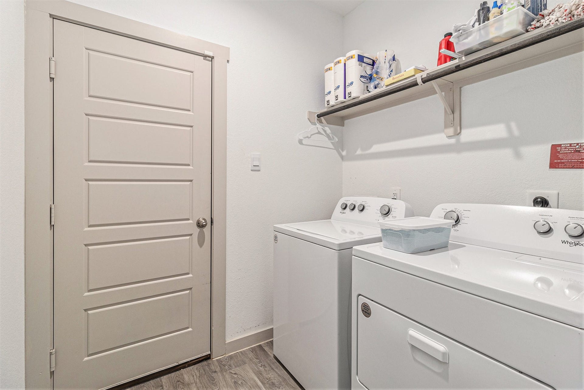 Dedicated first-floor laundry room with additional shelving for storage. Washer and dryer are included with the home.