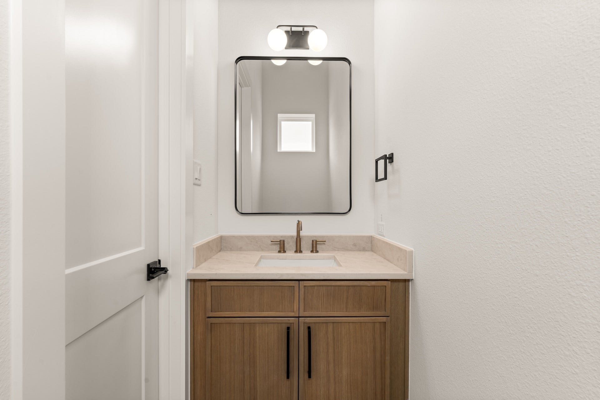6619 Avenue Q, #B, Houston, TX 77011 Convenient powder room with natural-toned vanity and warm brass fixtures serving guests on the living floor.