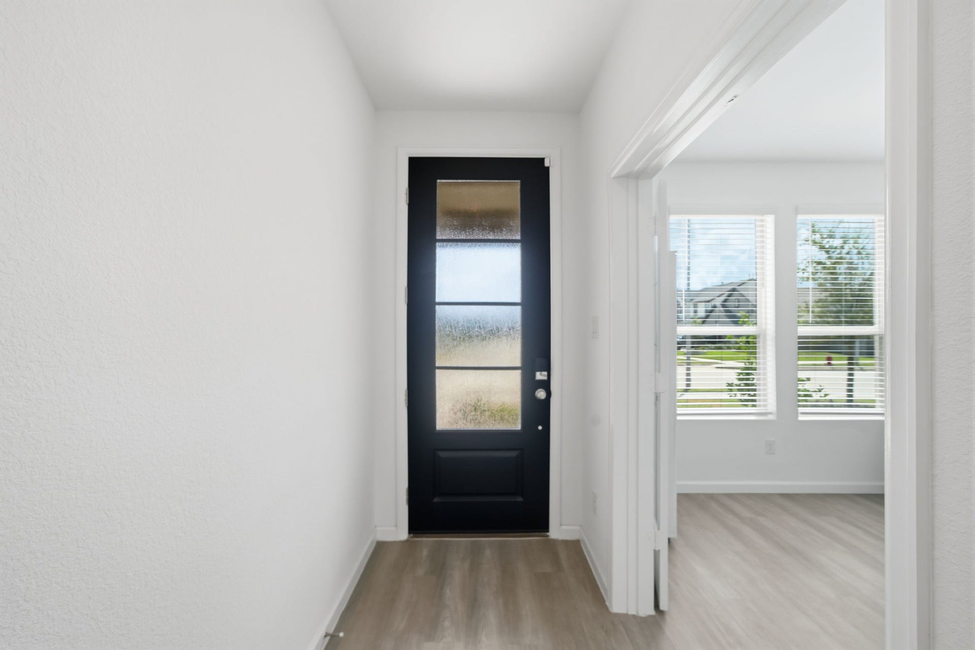 2446 Rosemary Sage Drive, Brookshire, TX 77423 Step inside through the beautiful wooden front door with privacy glass, where a welcoming hallway leads through the home and a dedicated study with French doors awaits to the left, perfect for a home office or quiet workspace.