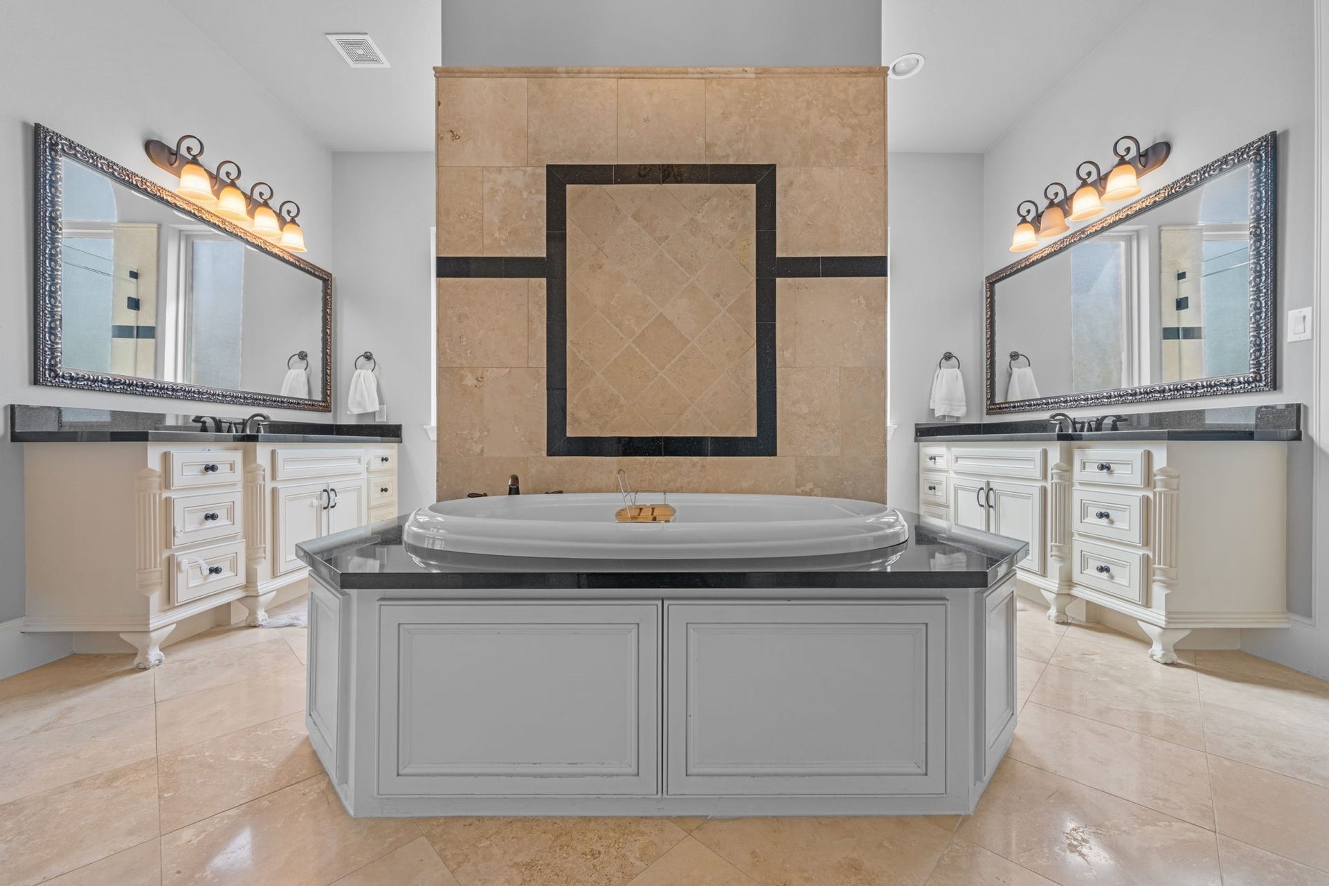 Spa-like primary bath with separate vanities, soaking tub, and generous storage
