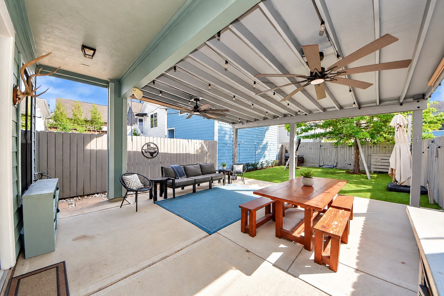 832 W 22nd Street, Houston, TX 77008 Beautiful outdoor living space featuring an expansive covered patio, ceiling fans, and a low-maintenance backyard with artificial turf. An ideal setting for gatherings, outdoor dining, and everyday enjoyment.