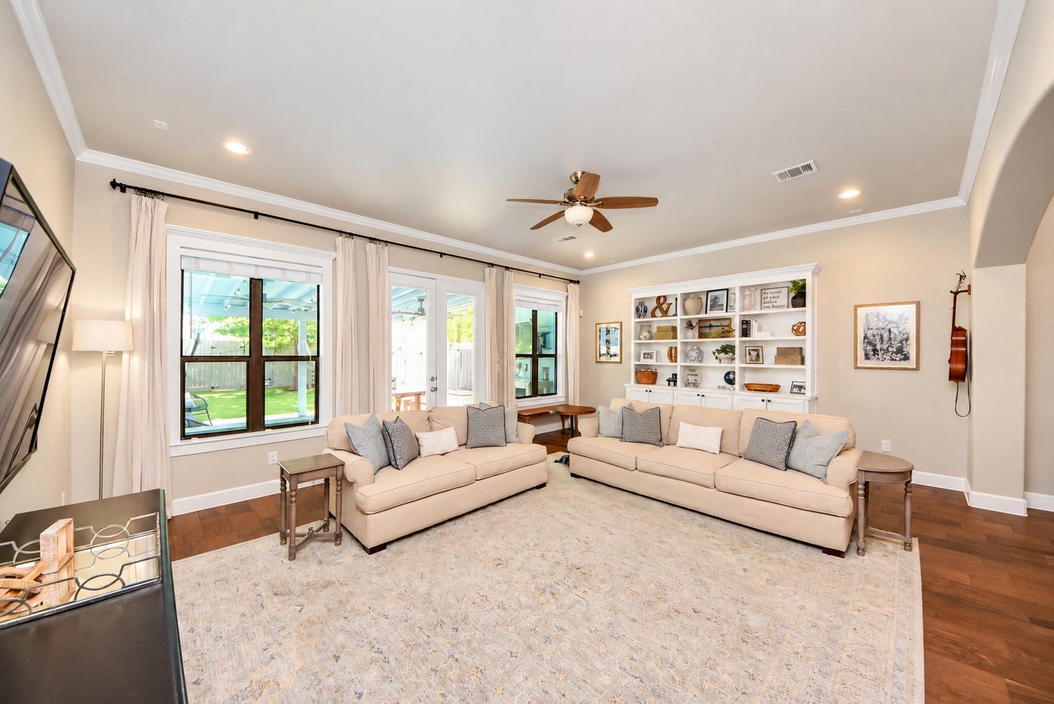 832 W 22nd Street, Houston, TX 77008 Spacious living room filled with natural light, featuring custom built-in shelving, beautiful wood floors, and backyard views.