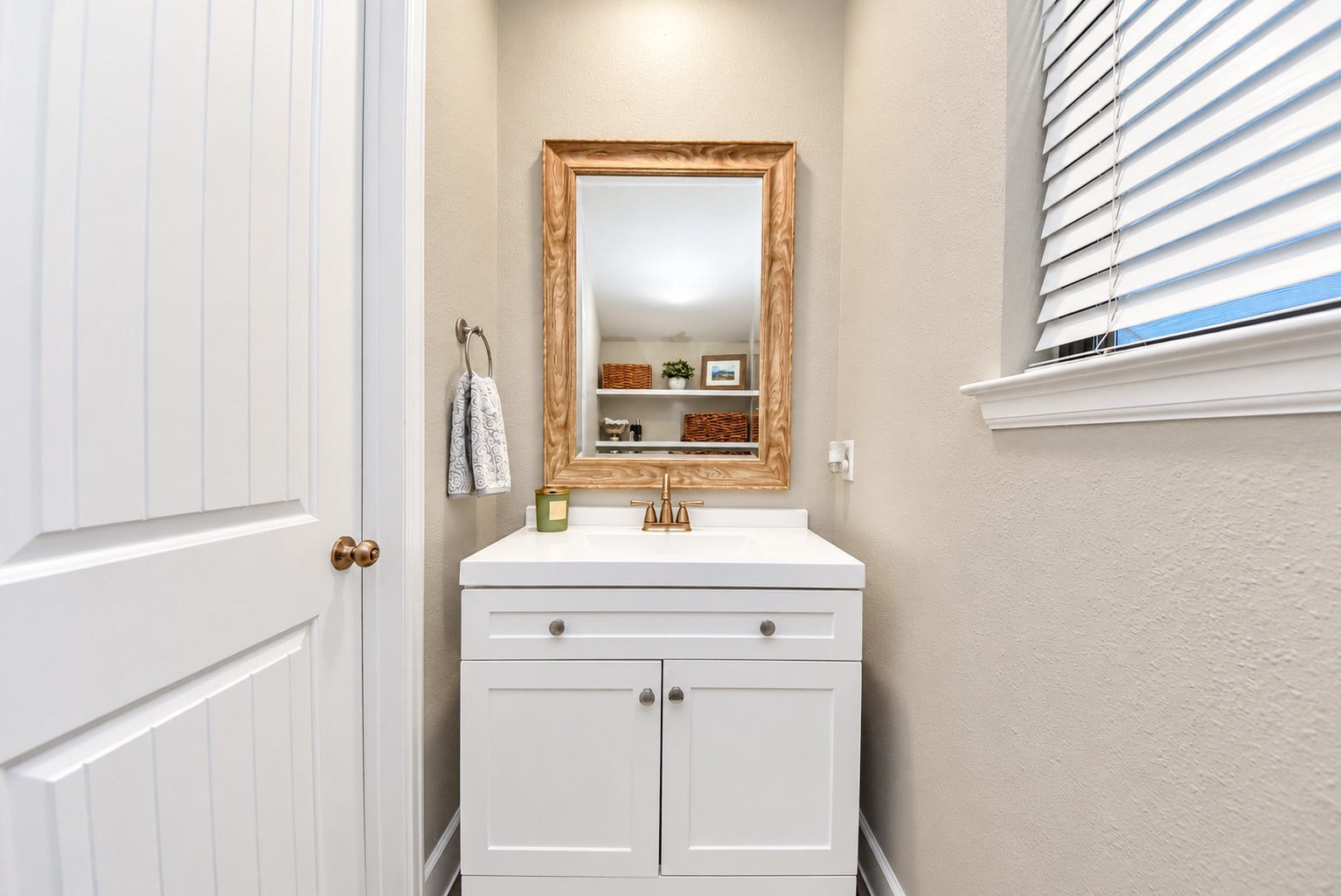832 W 22nd Street, Houston, TX 77008 Conveniently located powder room featuring a white vanity, decorative mirror, and warm-toned fixtures.