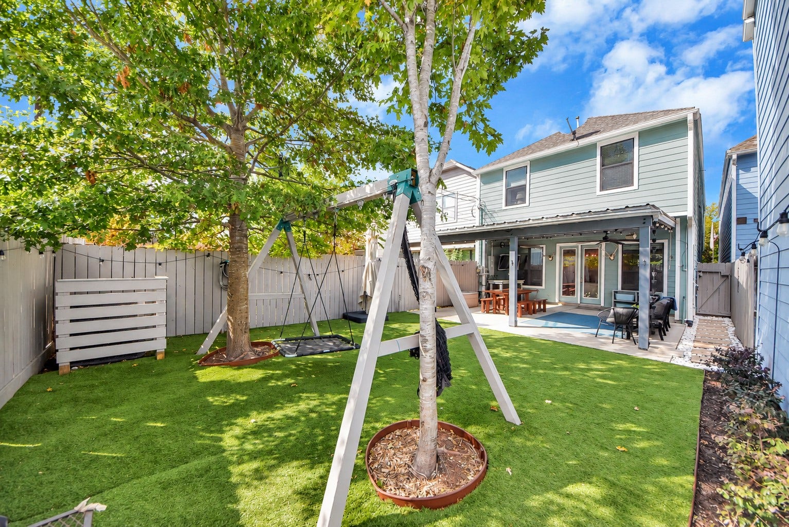 832 W 22nd Street, Houston, TX 77008 Beautiful outdoor living space featuring an expansive covered patio, ceiling fans, and a low-maintenance backyard with artificial turf. An ideal setting for gatherings, outdoor dining, and everyday enjoyment.