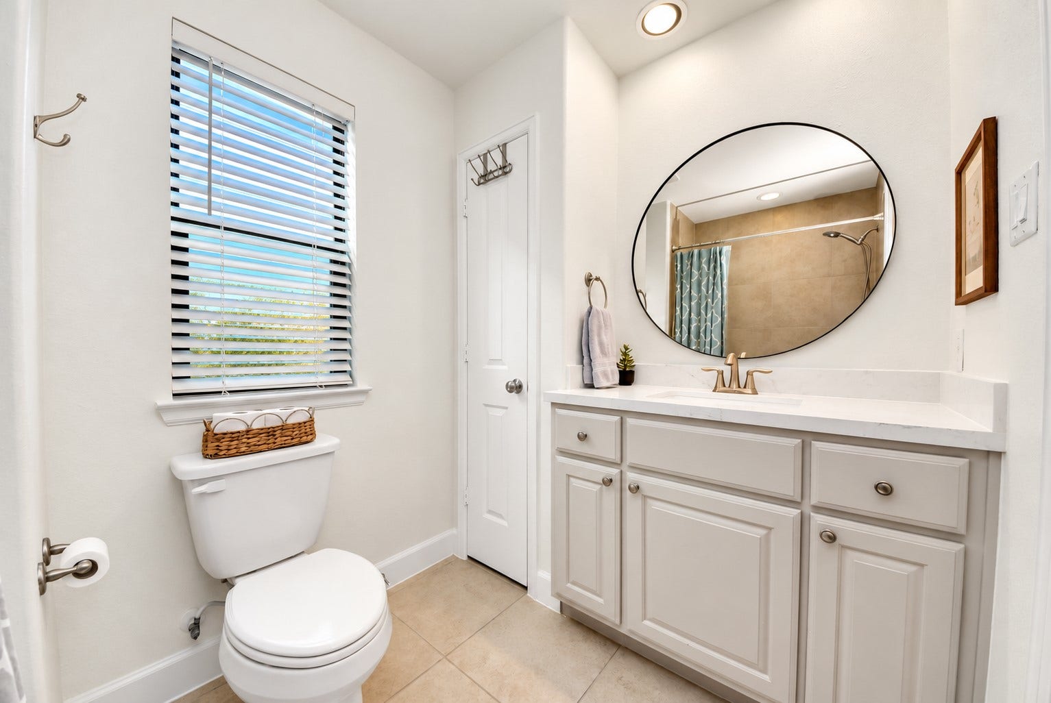 832 W 22nd Street, Houston, TX 77008 Bright secondary bathroom featuring a spacious vanity with generous countertop space, stylish round mirror, updated fixtures, and natural light.