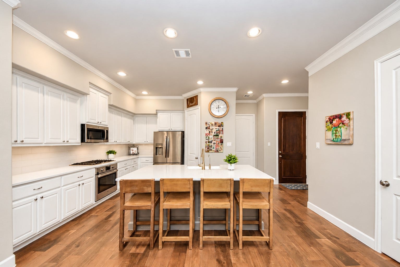 832 W 22nd Street, Houston, TX 77008 Spacious kitchen featuring white cabinetry, stainless steel appliances, generous counter space, and an oversized island with seating for four.