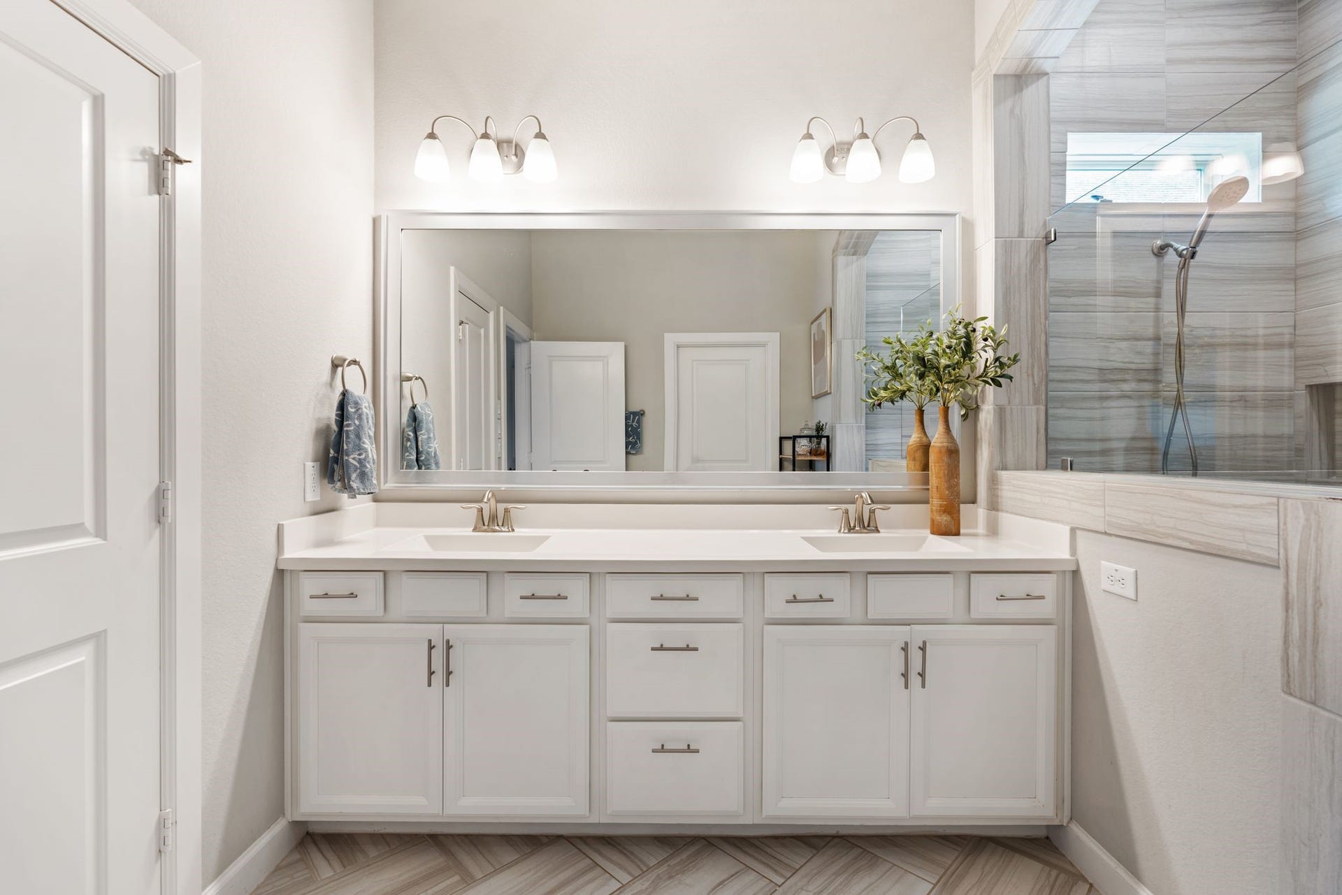 Double sinks with wash room to your left and walk-in closet behind you.