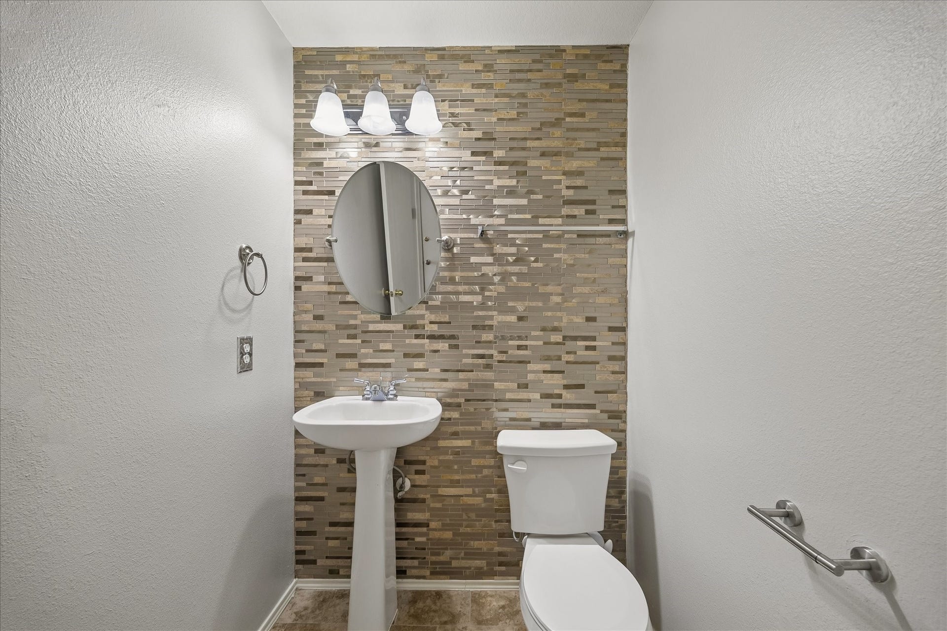 223 Sunset Colony Drive, Rosharon, TX 77583 This downstairs powder bath keeps daily living convenient with a stylish accent wall, pedestal sink, sleek mirror, updated vanity lighting and a clean, streamlined look.