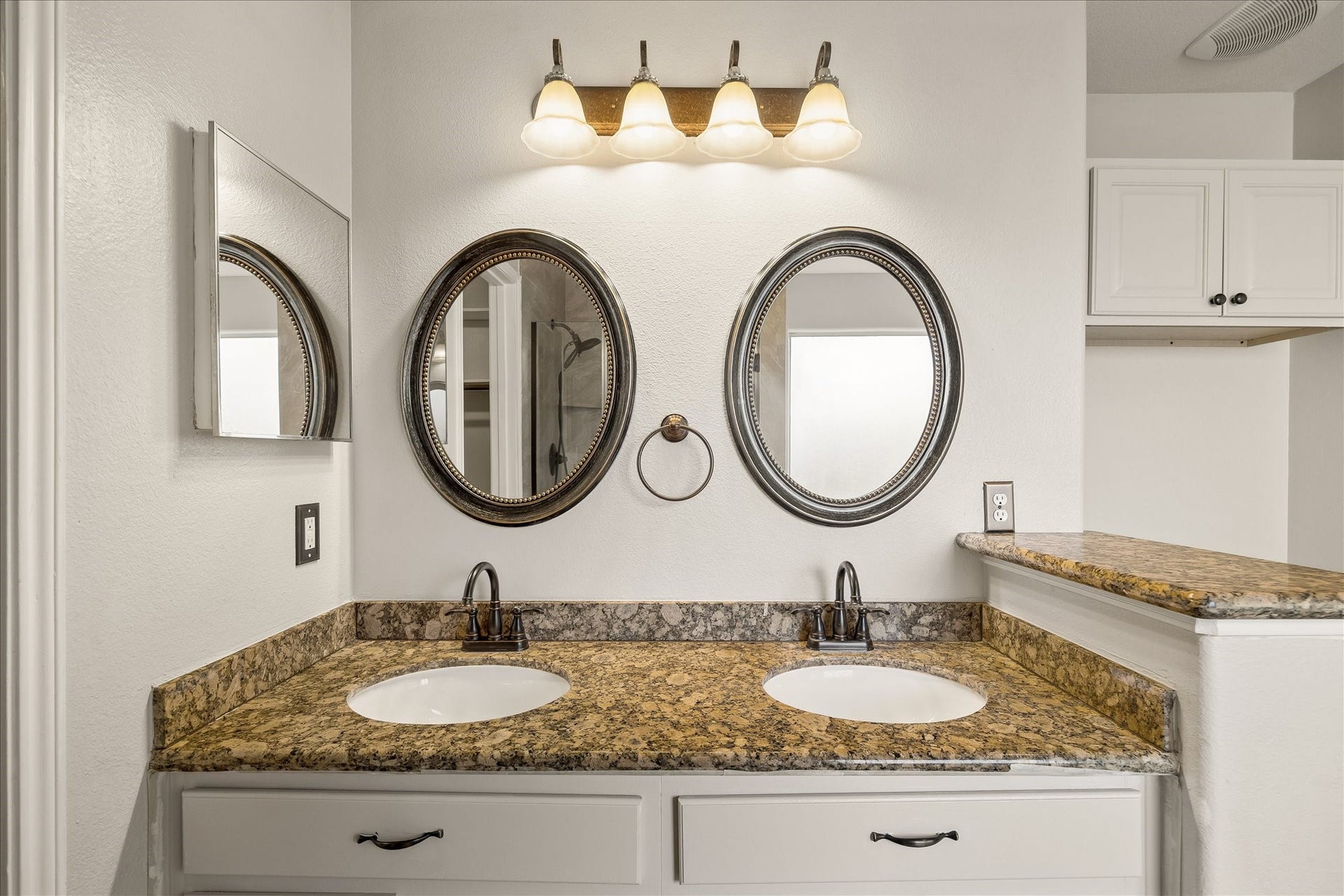 223 Sunset Colony Drive, Rosharon, TX 77583 The owner's private ensuite bathroom features a granite topped dual sink vanity with extensive storage below and framed mirrors with stylish vanity lights above.