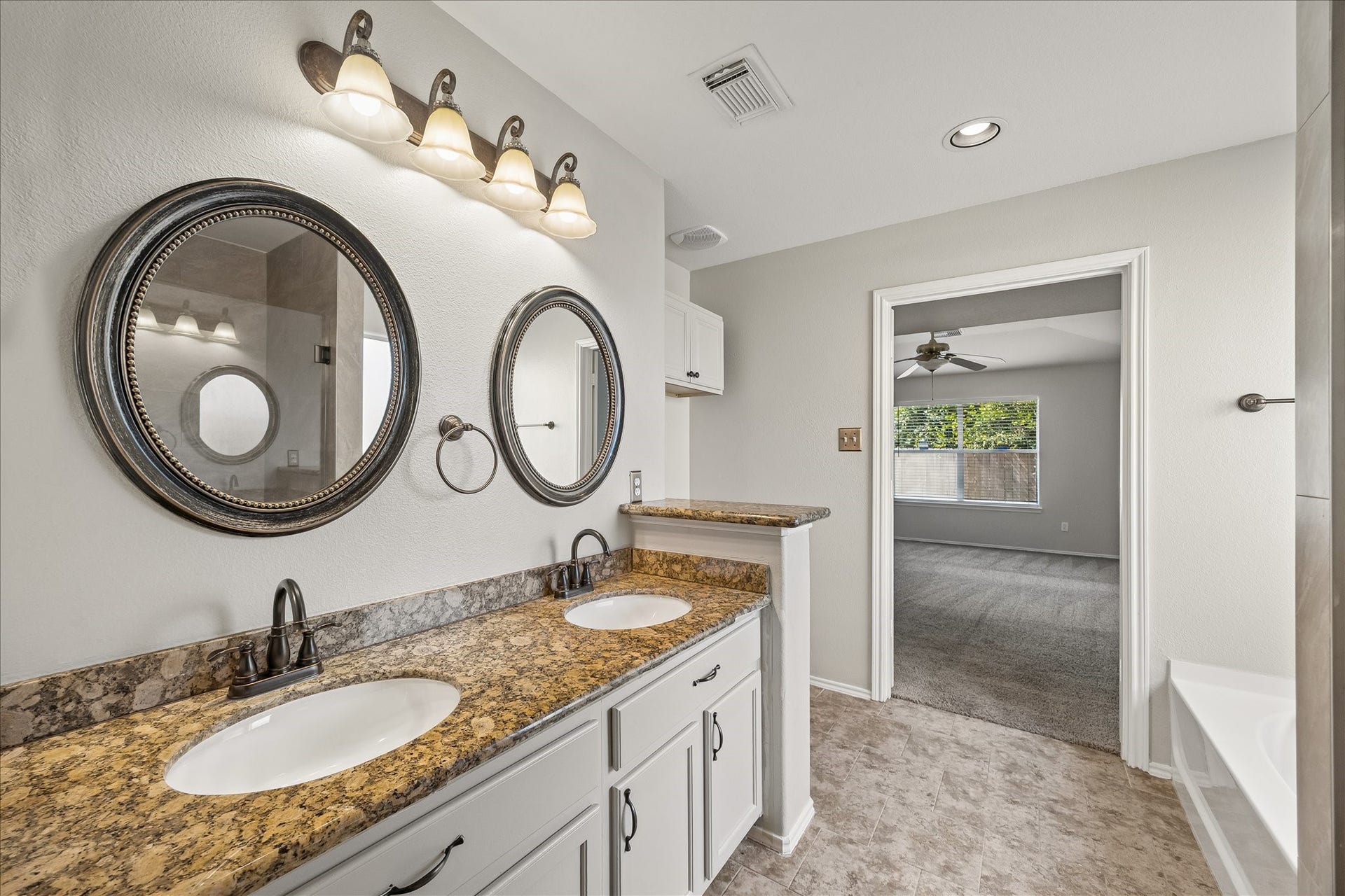 223 Sunset Colony Drive, Rosharon, TX 77583 Another look at the ensuite shows off the roomy layout with dual sinks, warm bronze finishes and plenty of space to get ready without feeling crowded.