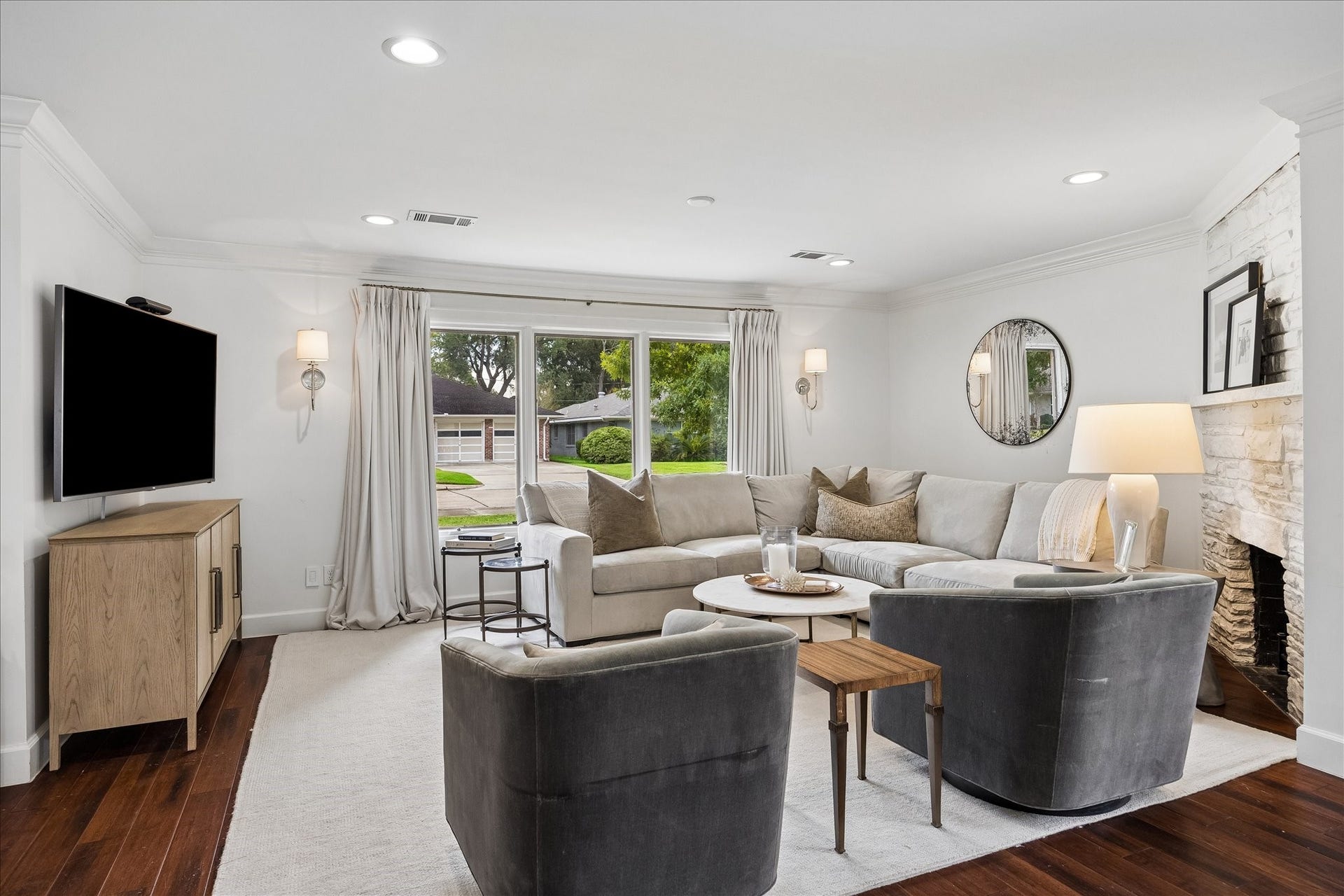 3702 Linkwood Drive, Houston, TX 77025 The living room boasts bamboo flooring, a mock fireplace, Visual comfort sconces and drapery.