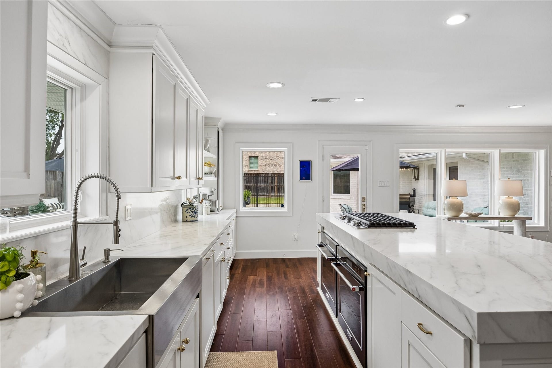 3702 Linkwood Drive, Houston, TX 77025 Gorgeous kitchen renovated (2025) with stainless sink, Symphony Quartz on the island, counters and ceiling height backsplash. KitchenAid ovens and cooktop with new Bosch dishwasher.